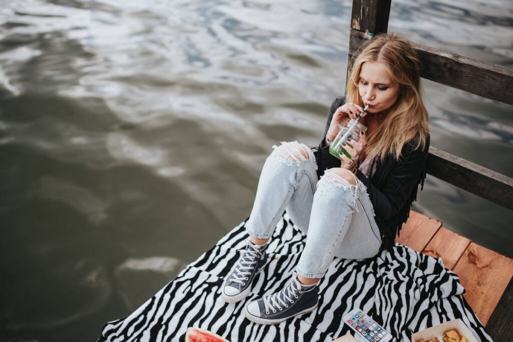 Blonde woman having a healthy snack at the wooden pier Stock Free