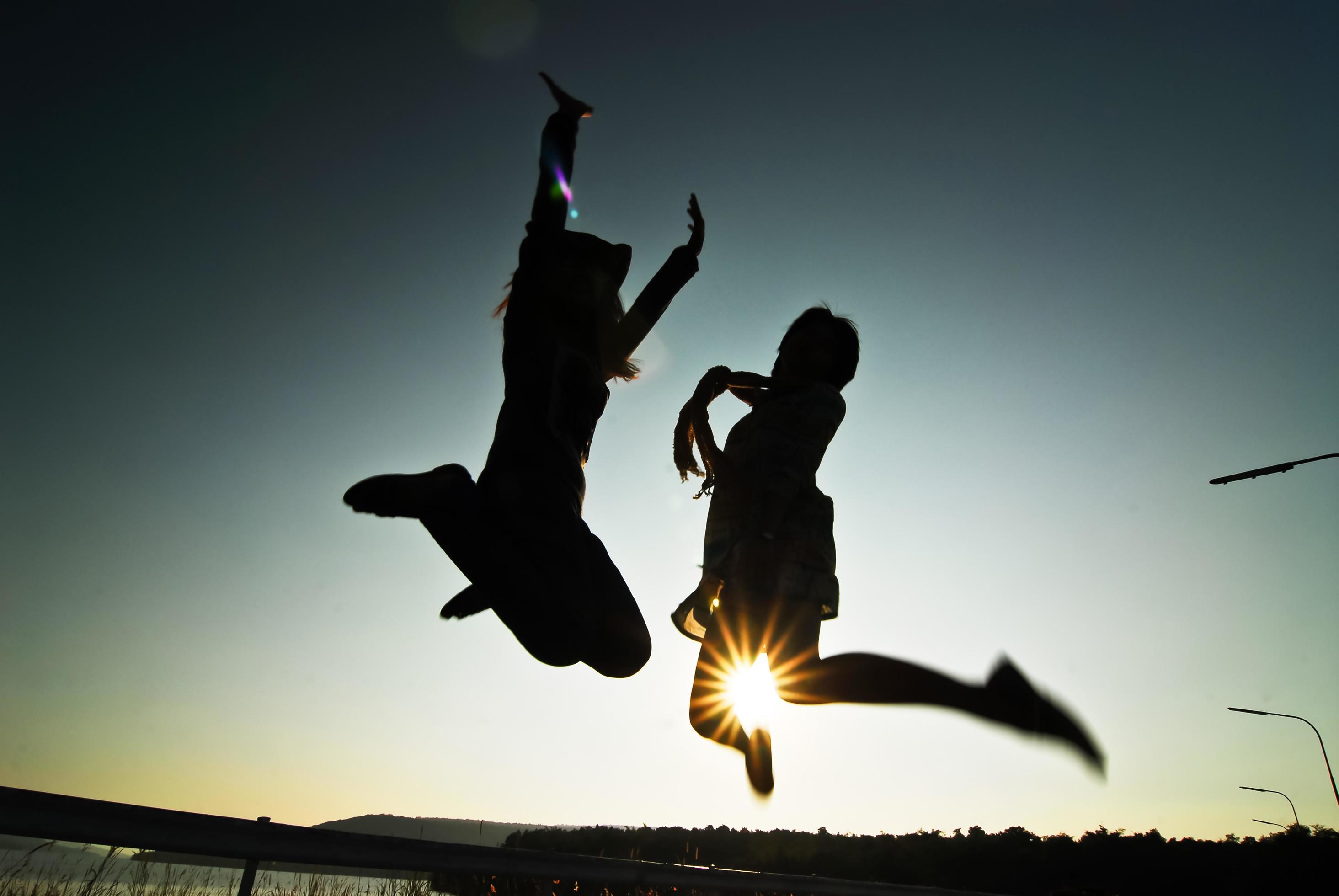 Silhouette happy woman jumping against beautiful in sunset. Freedom, enjoyment concept. Stock Free