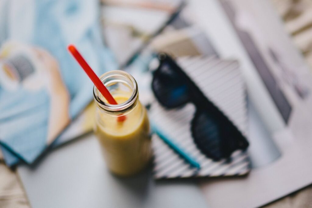 Healthy shake in a small bottle with a straw and sunglasses Stock Free