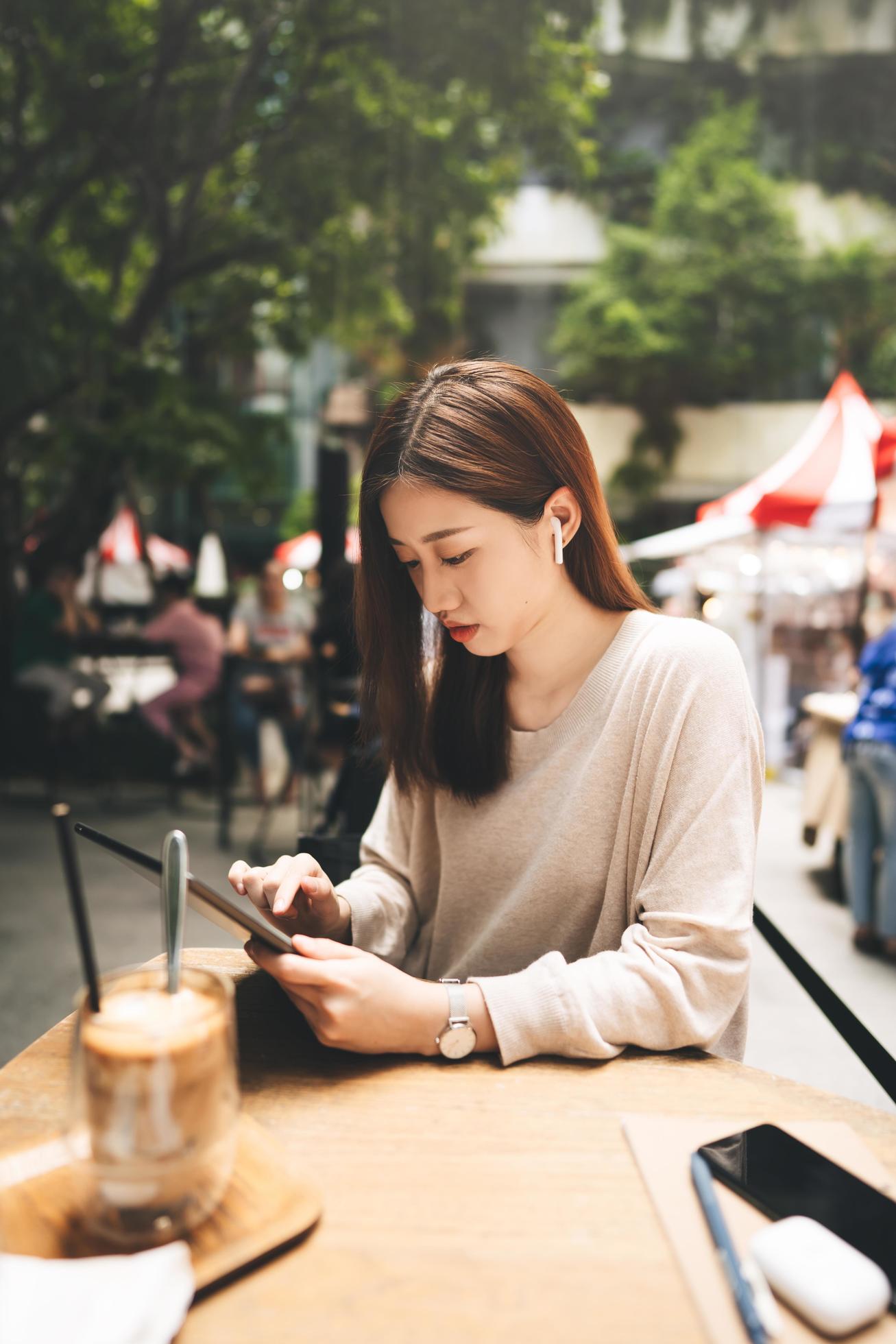 Young adult business asian woman use tablet for business at outdoor city lifestyle cafe. Stock Free