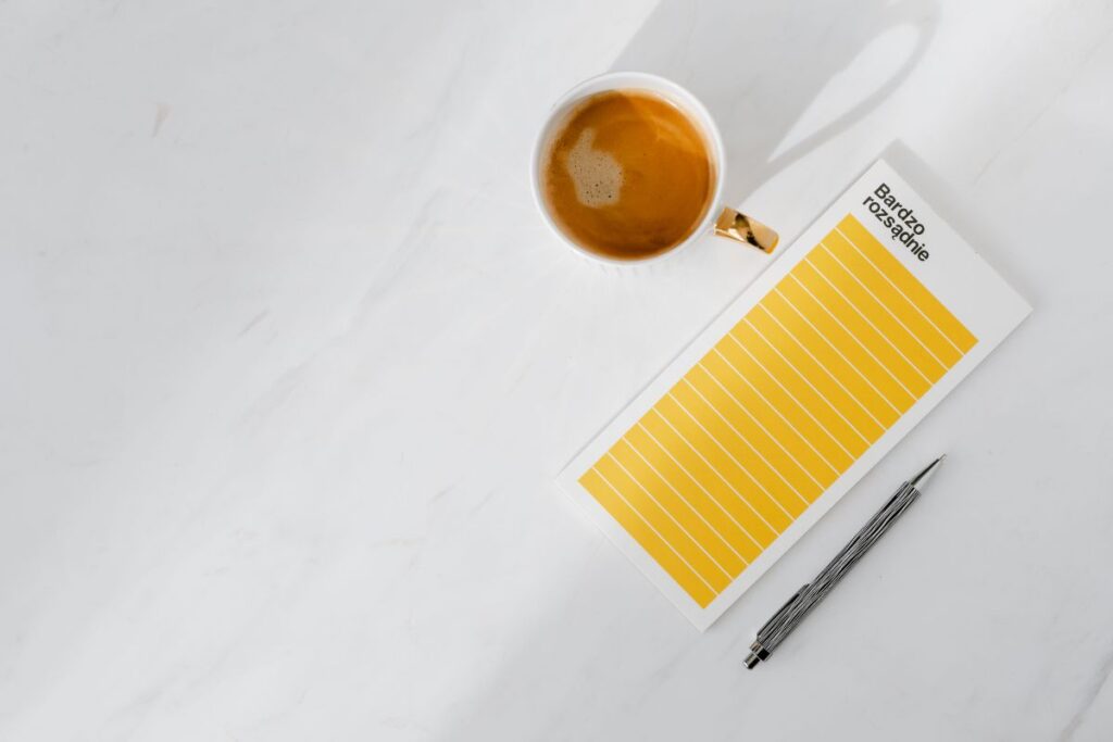 Top view of a marble desk with coffee, notebooks and pen Stock Free