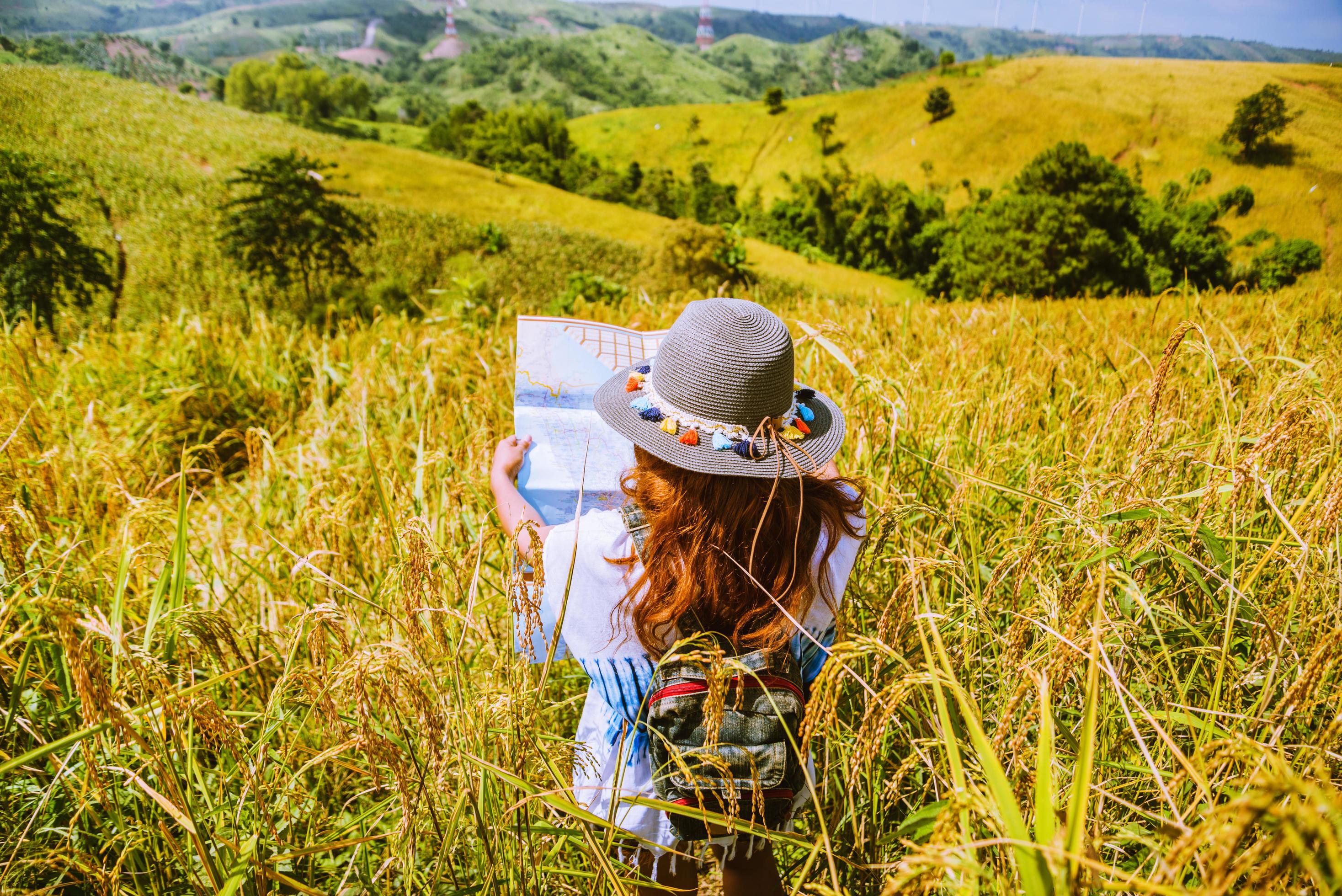 Asian women travel relax in the holiday. Stand natural touch mountain field summer. View map travel explore. In Thailand Stock Free