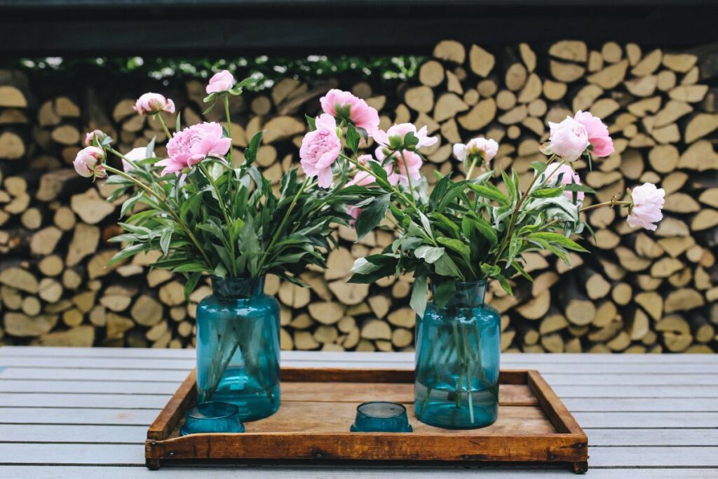 Pink flowers on a wooden table in a sunny garden Stock Free