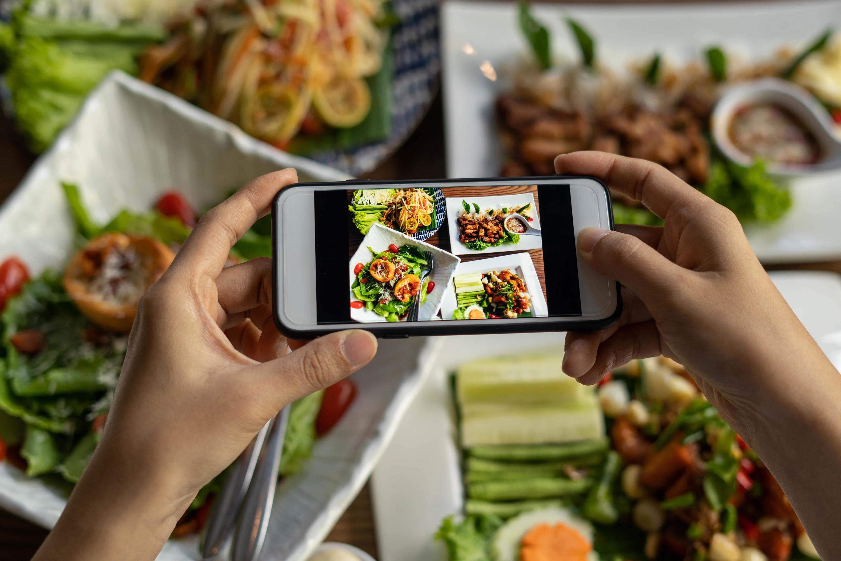 Woman take picture of a meal on the table after ordering food online to eat at home. Photography and use phone concepts Stock Free