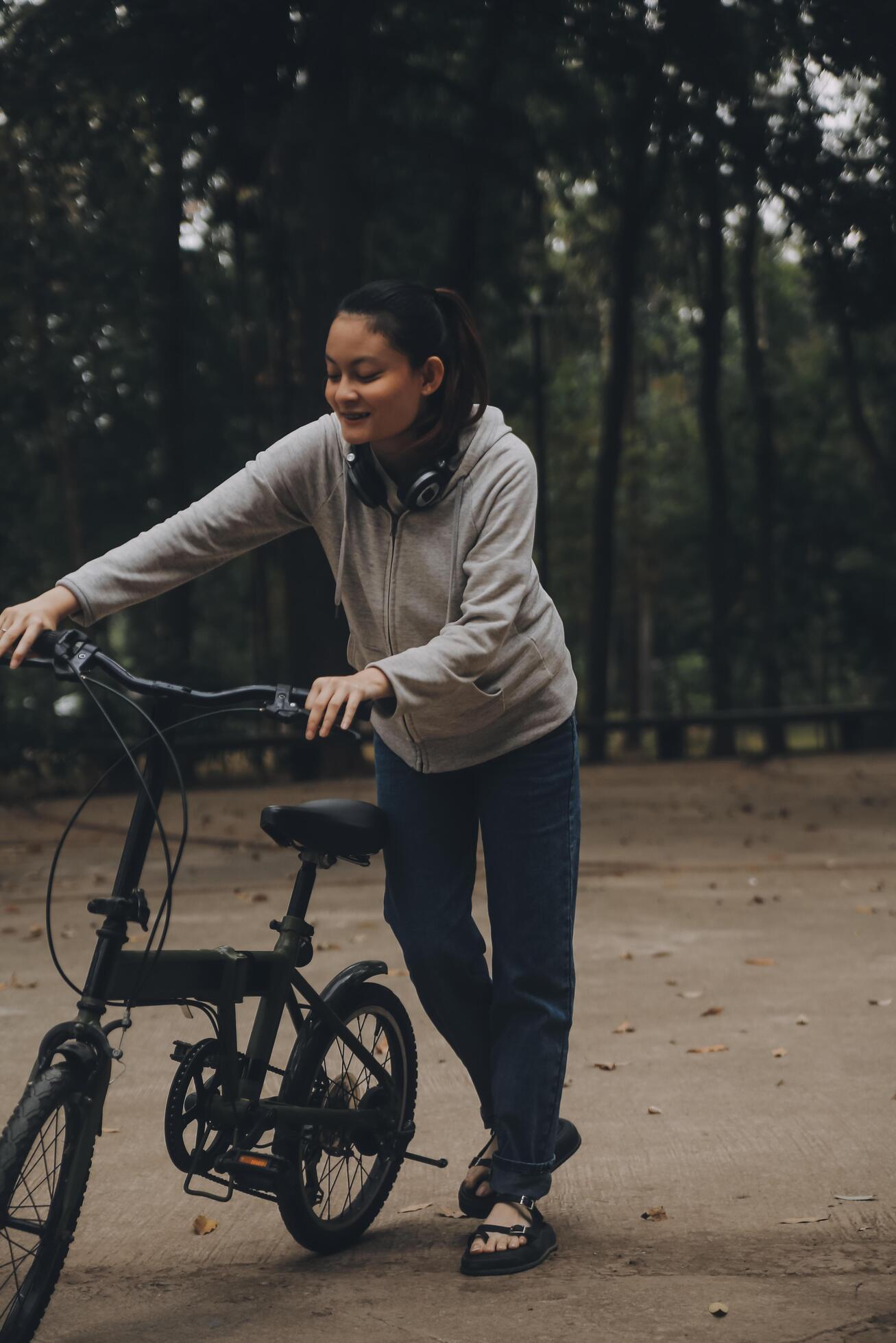 Happy Asian young woman walk and ride bicycle in park, street city her smiling using bike of transportation, ECO friendly, People lifestyle concept. Stock Free