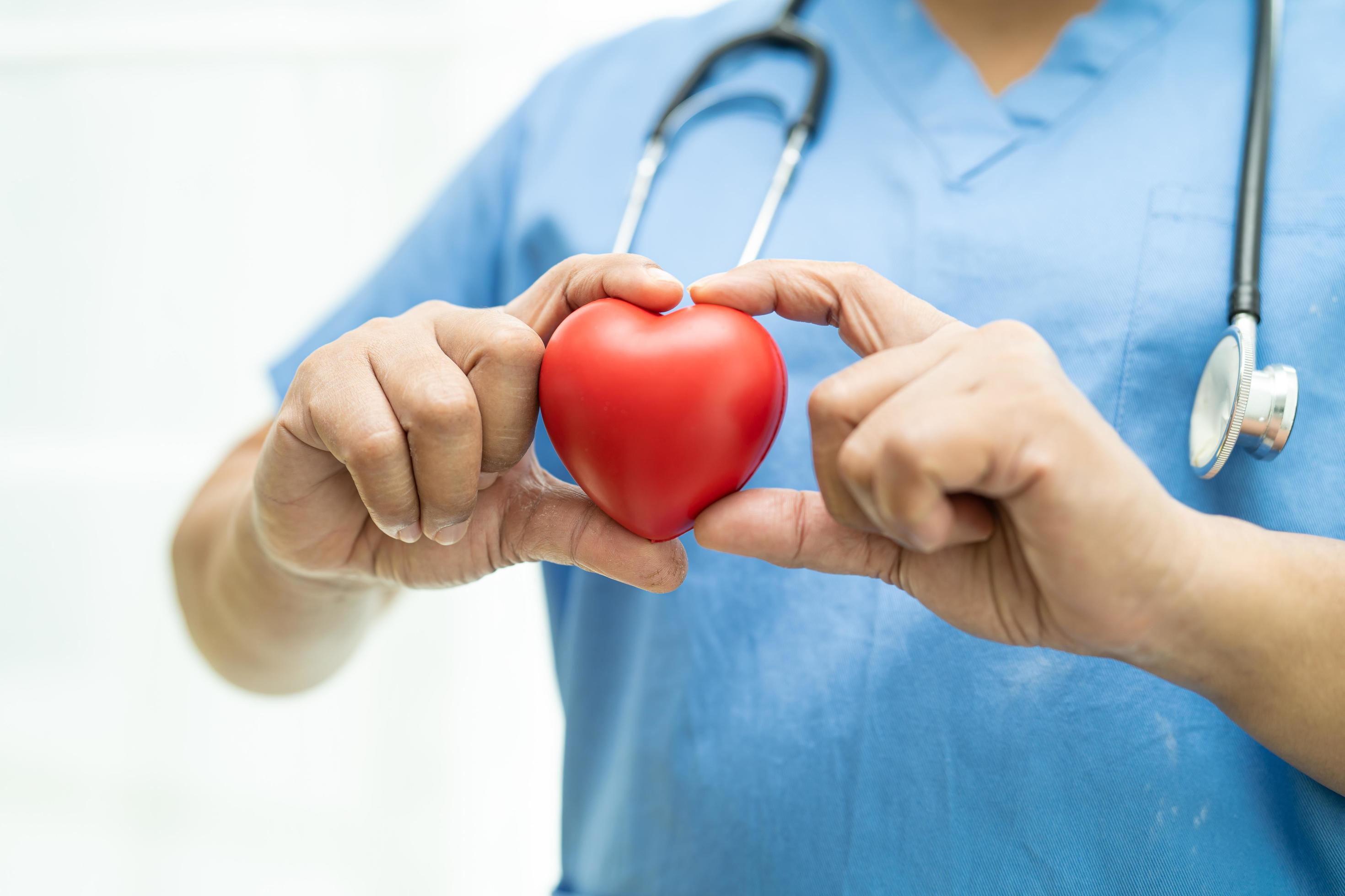 Asian senior or elderly old lady woman patient holding red heart in her hand on bed in nursing hospital ward, healthy strong medical concept Stock Free