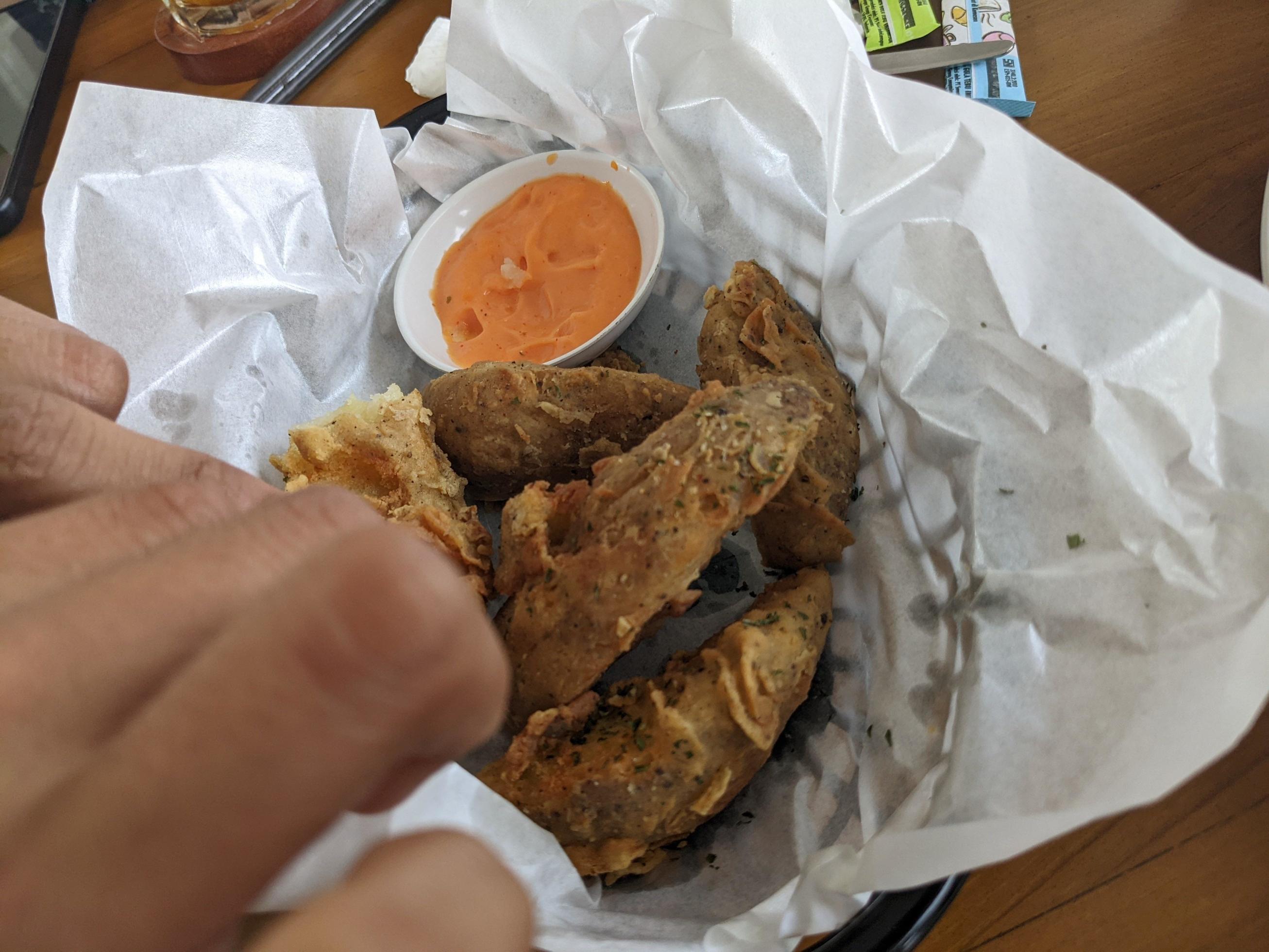 Potato wedges with cheese sauce over the white papers. The photo is suitable to use for food background, poster and food content media. Stock Free