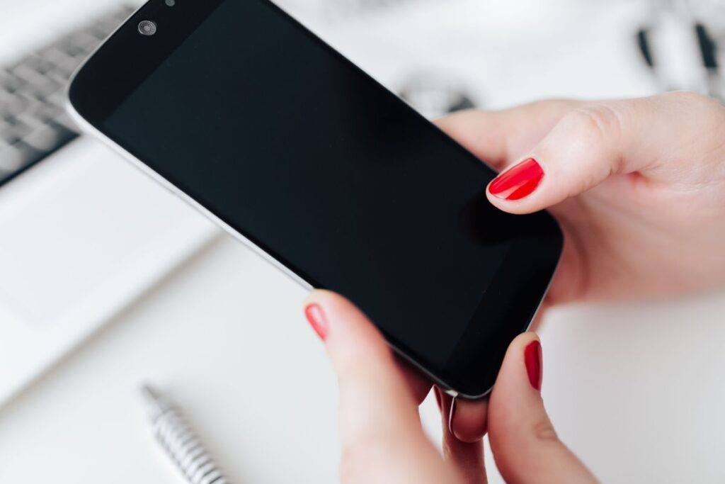 Businesswoman uses her mobile phone at her desk Stock Free