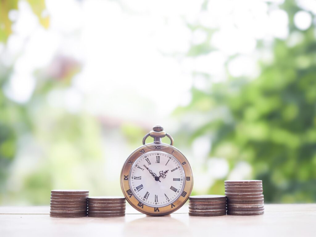 Vintage watch and stack of coins. The concept of saving money for manage time to success business. Stock Free