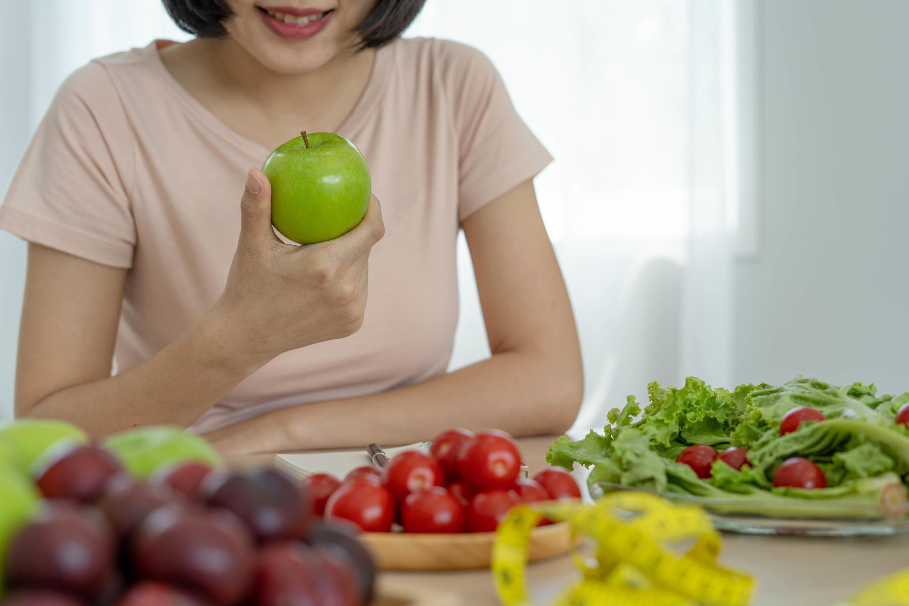 
									Healthy food and keto diet. Women plan dieting for slim shape and healthy. Woman eating apple and vegetables Stock Free