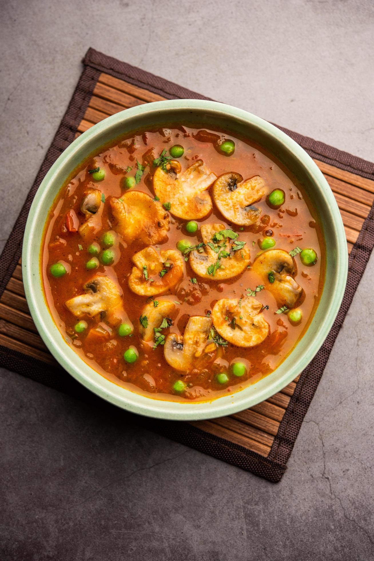 Mushroom and Pea Curry with Roasted Garlic, Indian food served in a bowl Stock Free