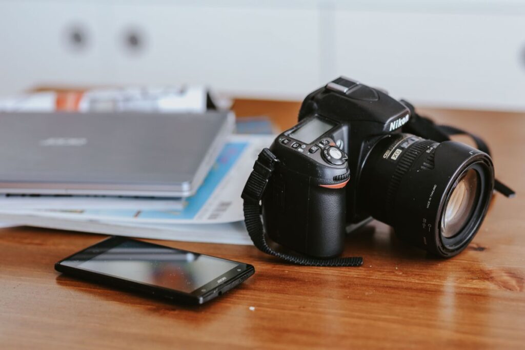 Laptop, a smartphone, magazines and cups of coffee on a table Stock Free