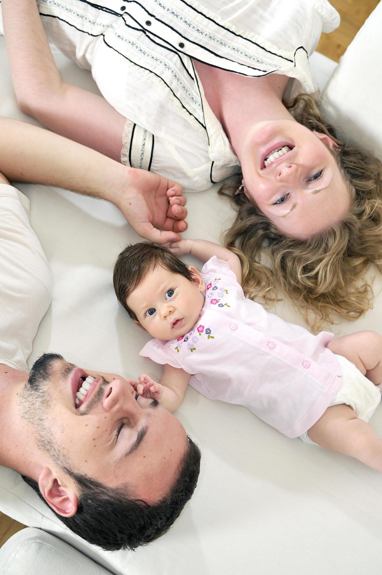 indoor portrait with happy young family and cute little babby Stock Free