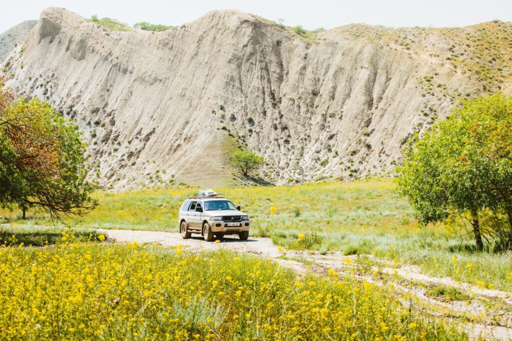 Front view 4WD on muddy off-road in wild nature outdoors on adventure extreme tour in caucasus mountains in hot day Stock Free