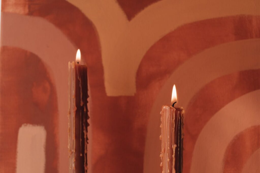 Orange-colored candles on the background of the painting Stock Free