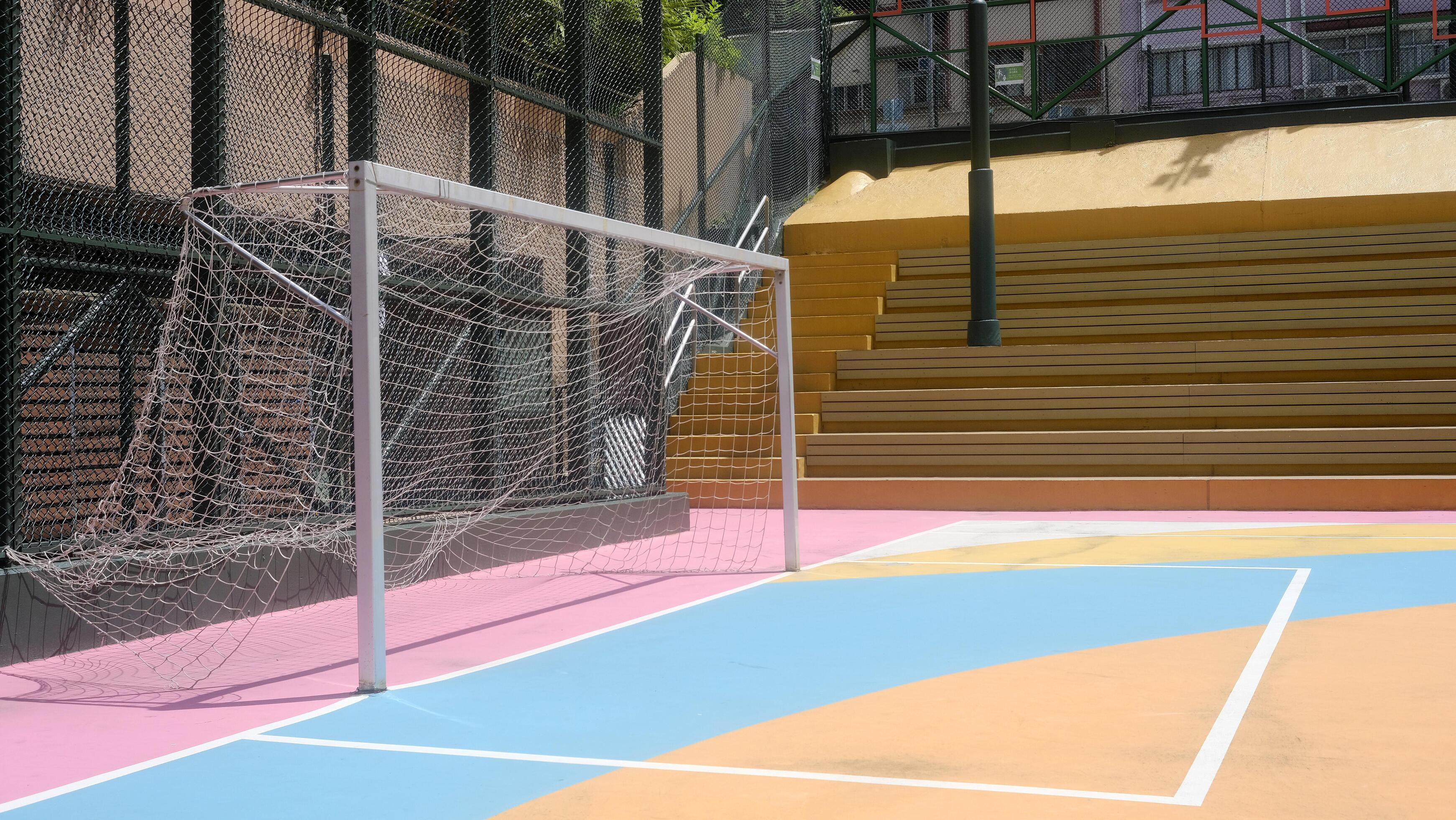 Colourful pink, blue, orange, soccer field and sport standsin the urban town with building background Stock Free