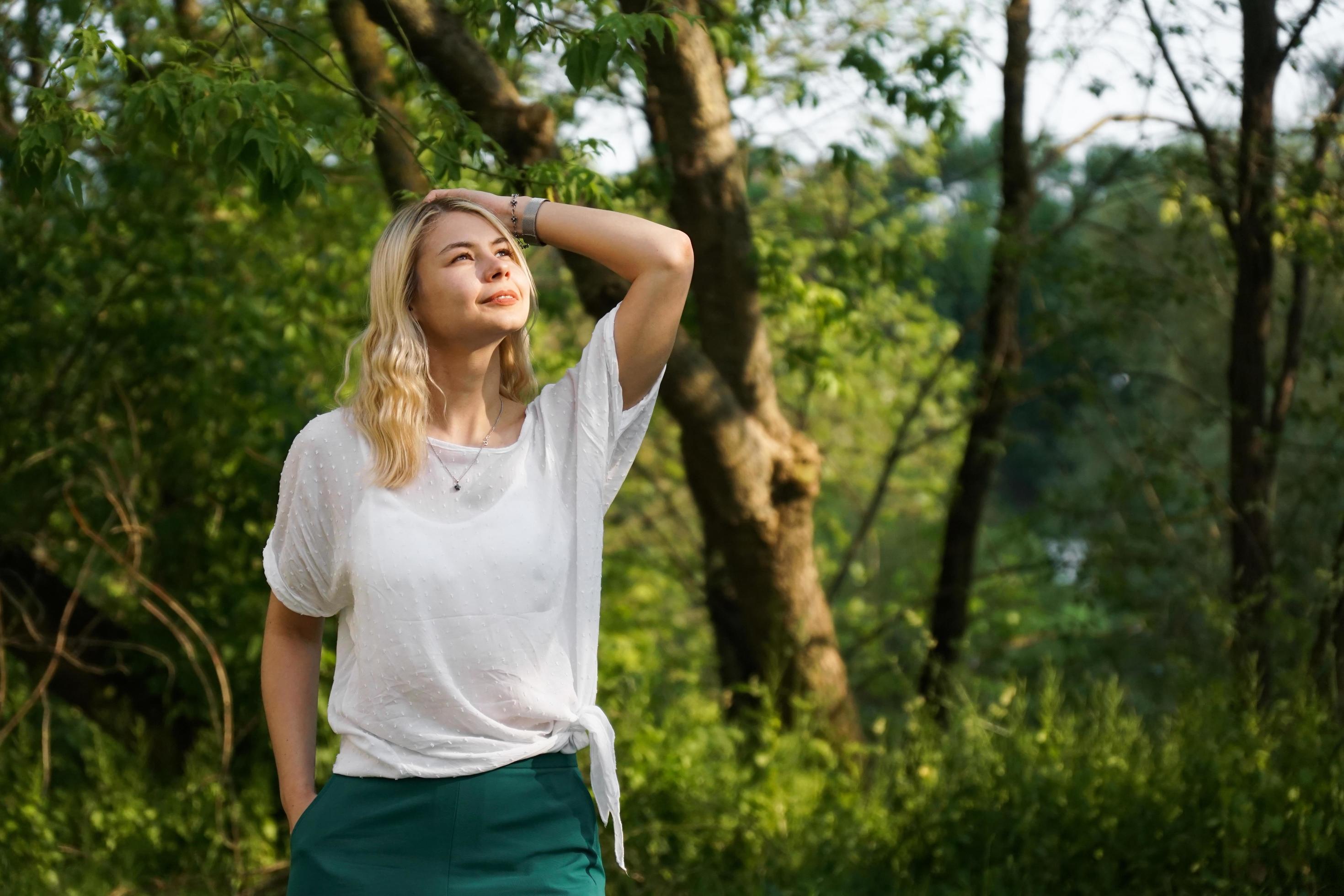 Beautiful young blonde in the forest. The girl enjoys nature Stock Free