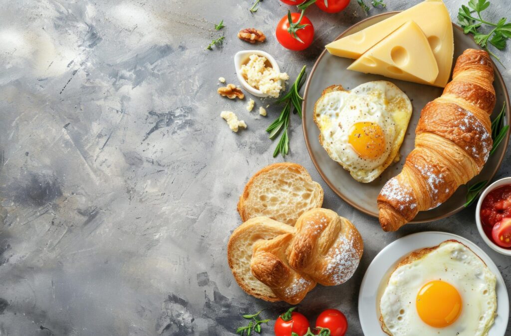 breakfast croissants, eggs, tomato, and cheese flat layout Free Photo