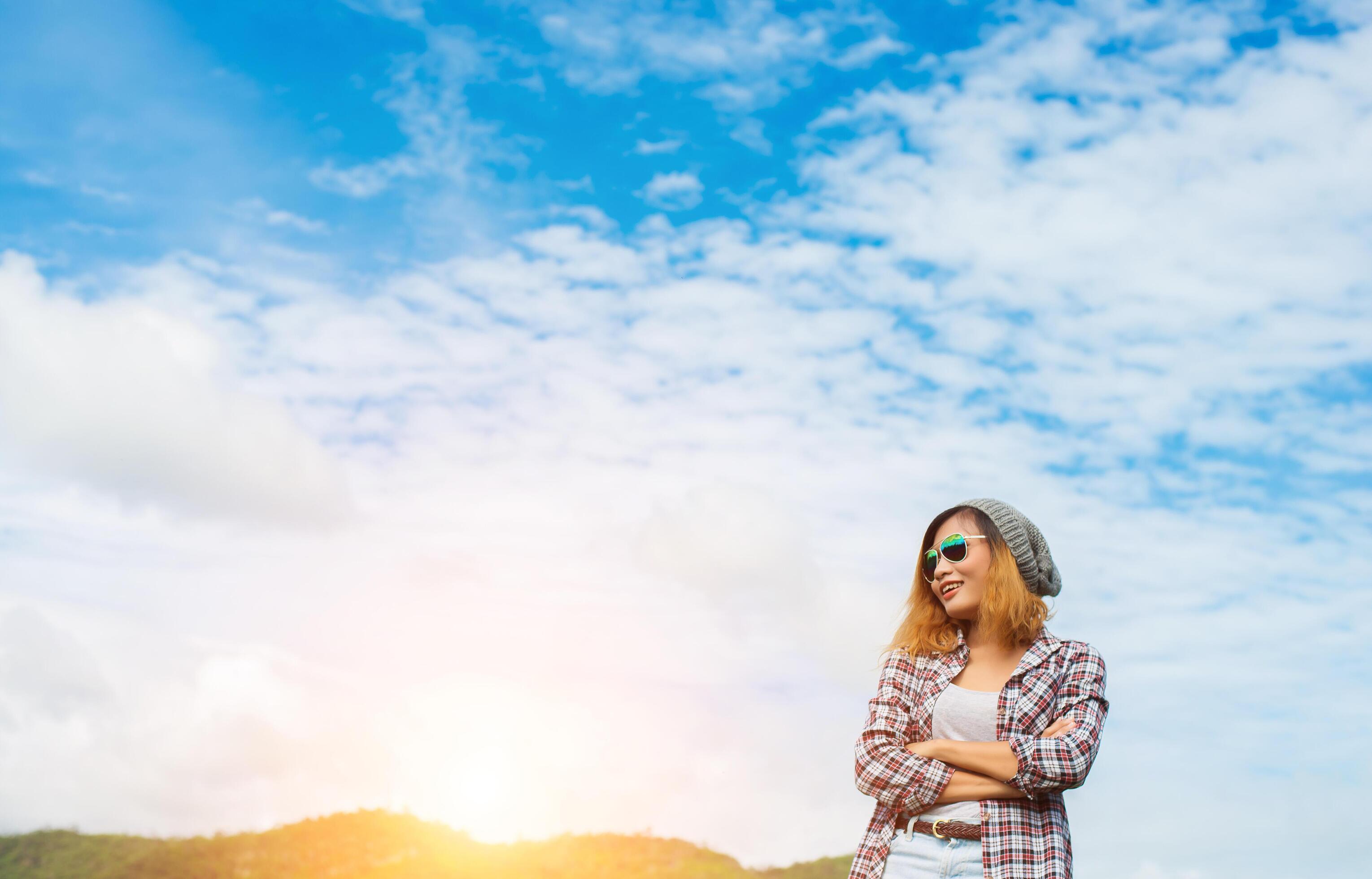 Young beautiful hipster woman standing crossed arms amidst nature and mountain ,Relaxing concept Stock Free