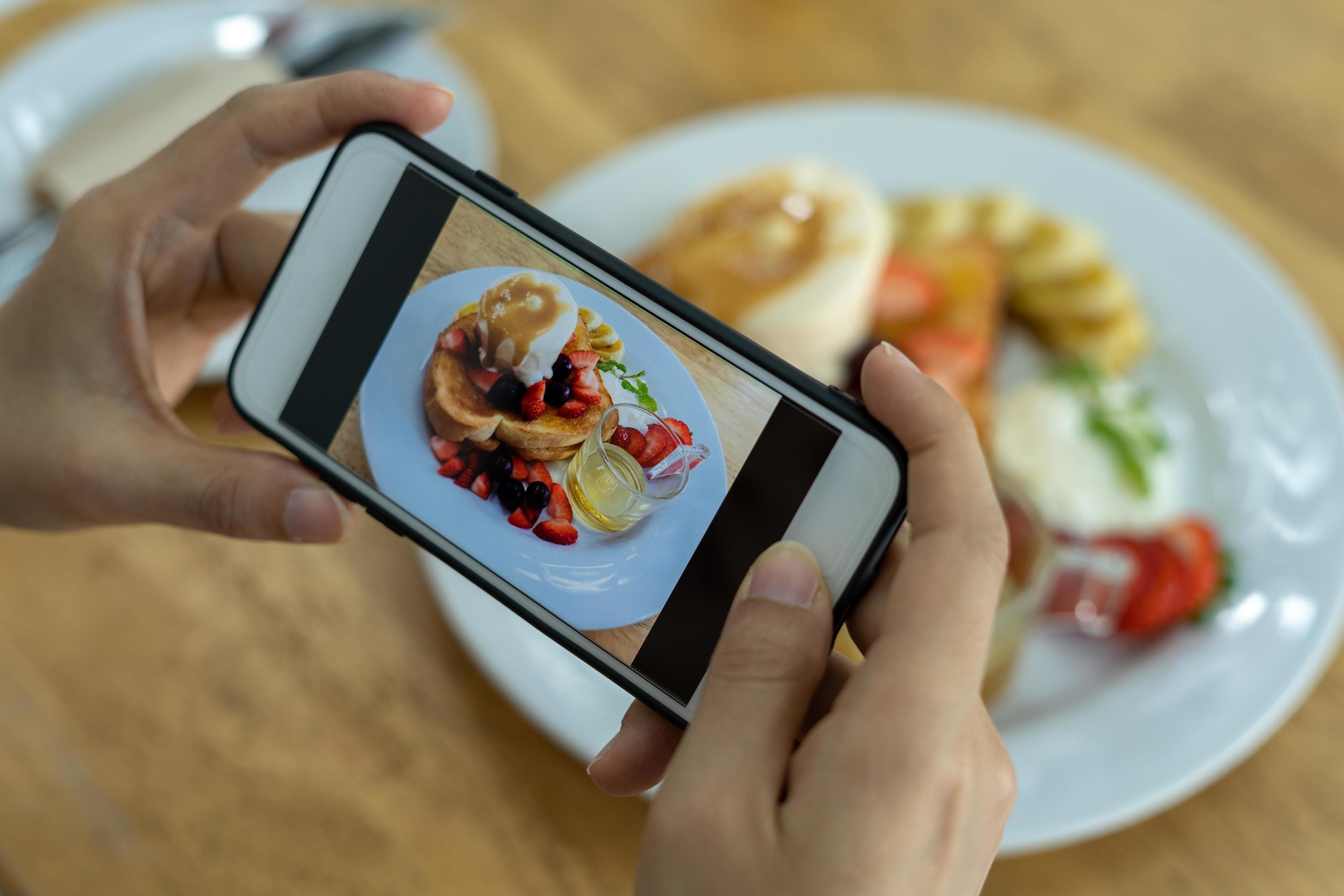 Woman take picture of a meal on the table after ordering food online to eat at home. Photography and use phone concepts Stock Free