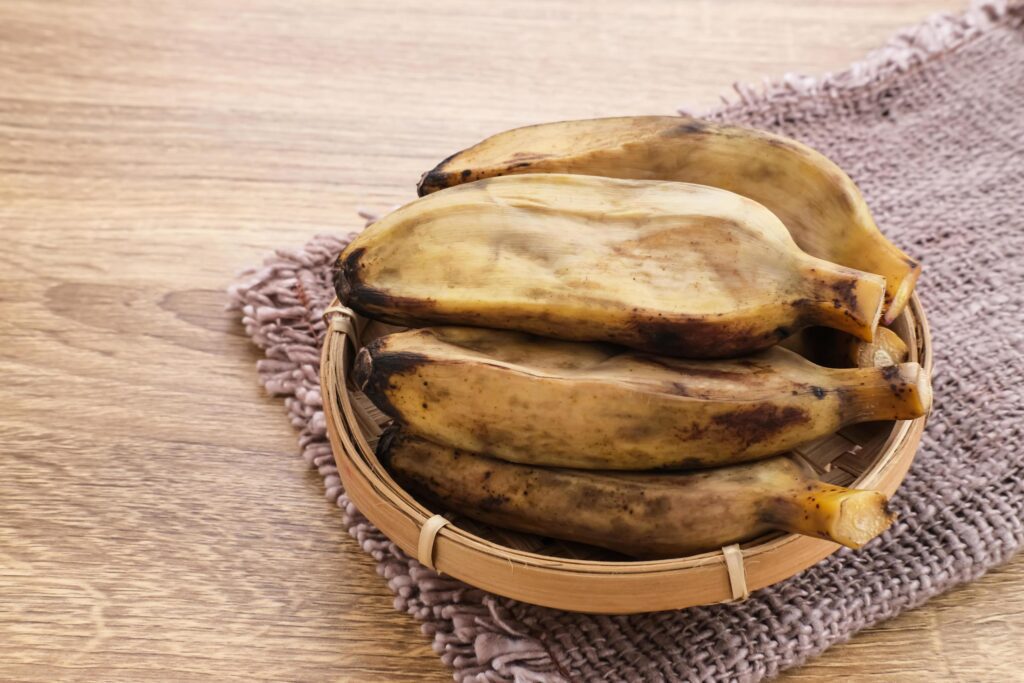 Pisang Kukus or Steamed Banana, Indonesian traditional food, a healthy snack. Served on wooden table. Close up. Stock Free