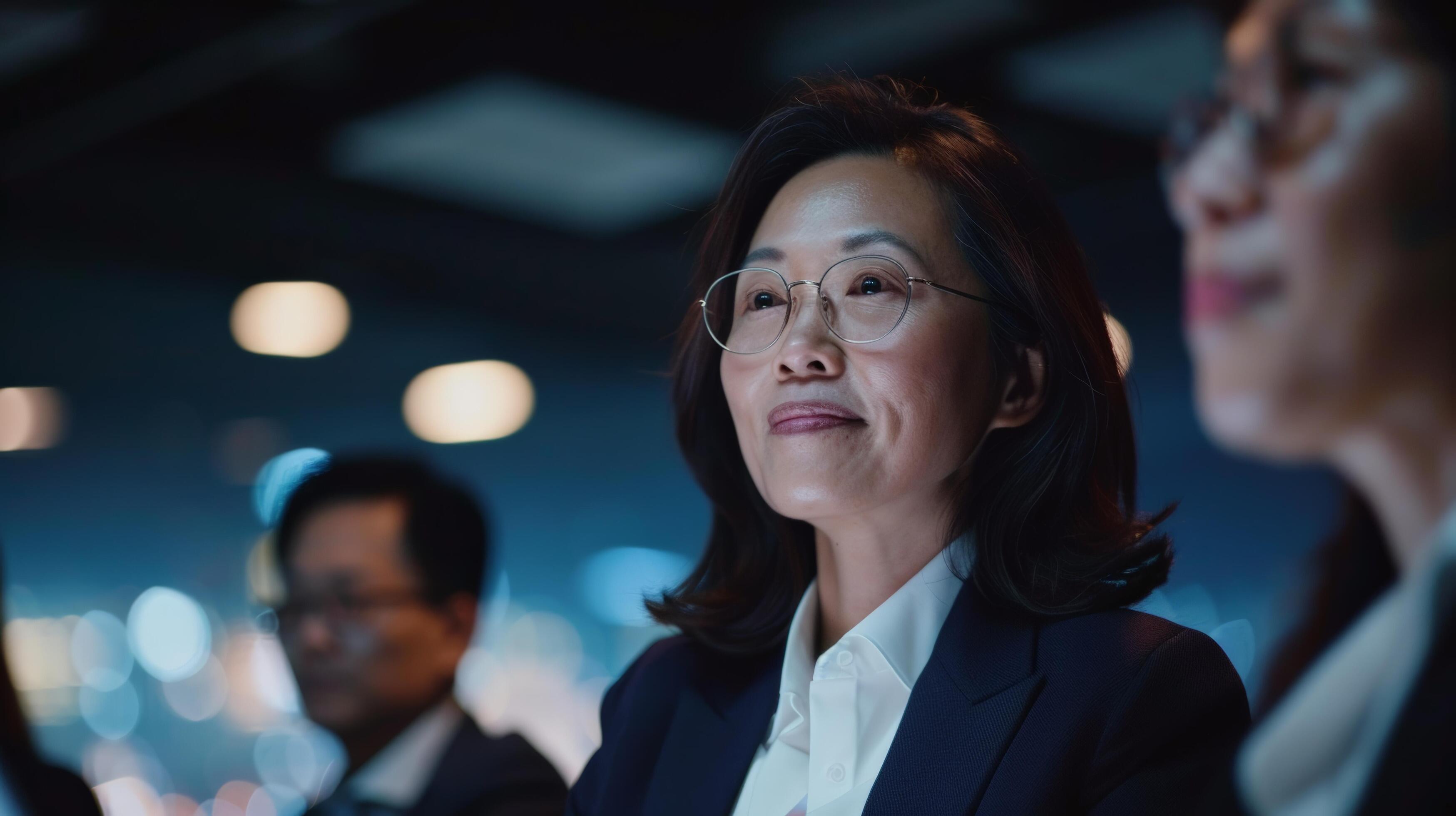 Business professionals attending a meeting, focusing on a thoughtful businesswoman in a corporate Stock Free