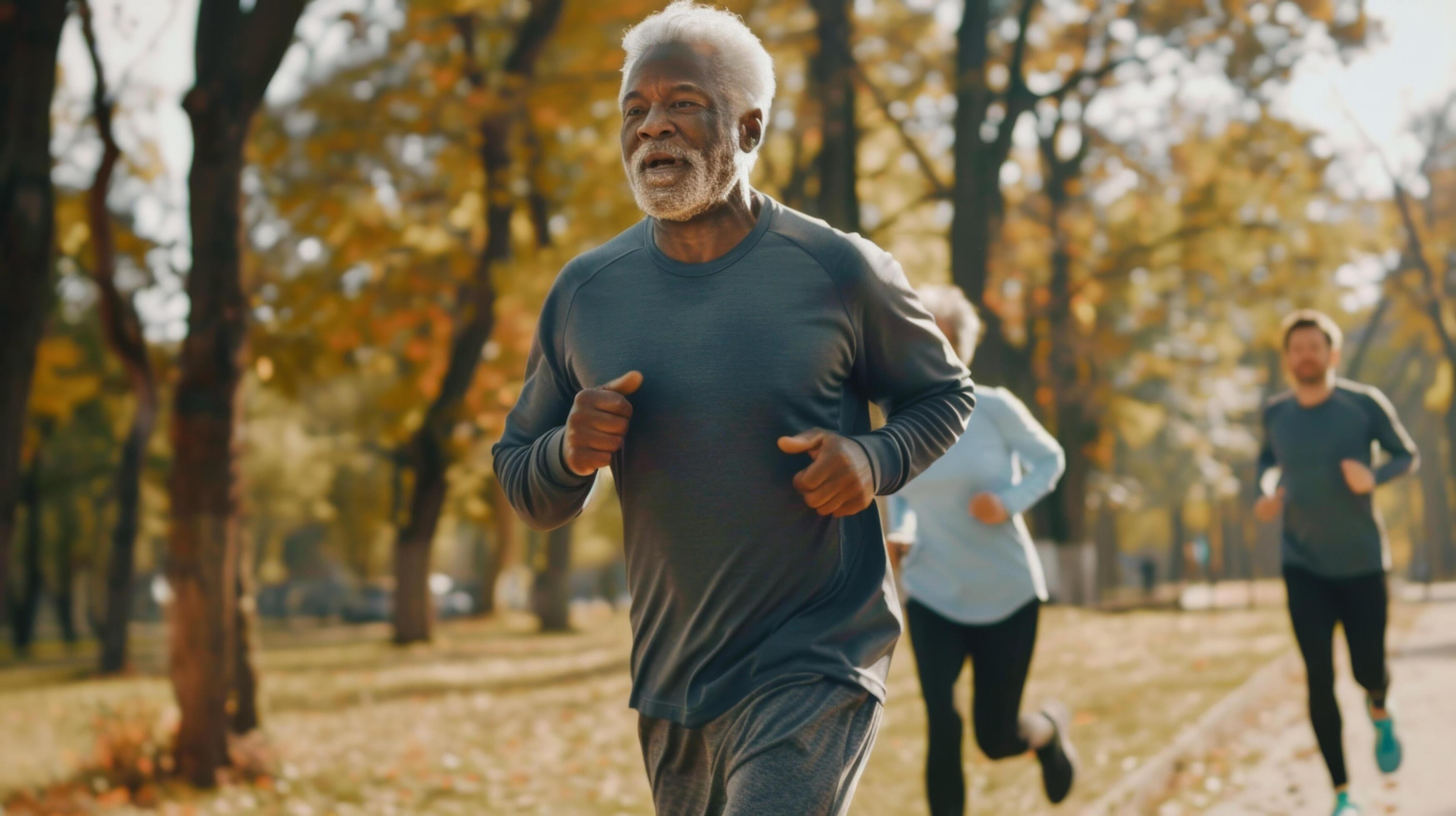 Senior man jogging in park with others during autumn morning. Outdoor fitness and healthy lifestyle concept. Stock Free