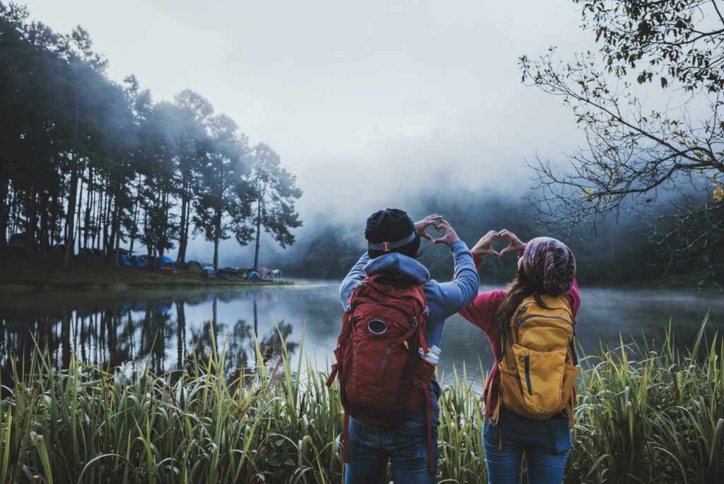 Couple lovers travel beatiful nature panorama view of Pang Ung lake in the mist at sunrise, Mae Hong Son province, Thailand. Stock Free