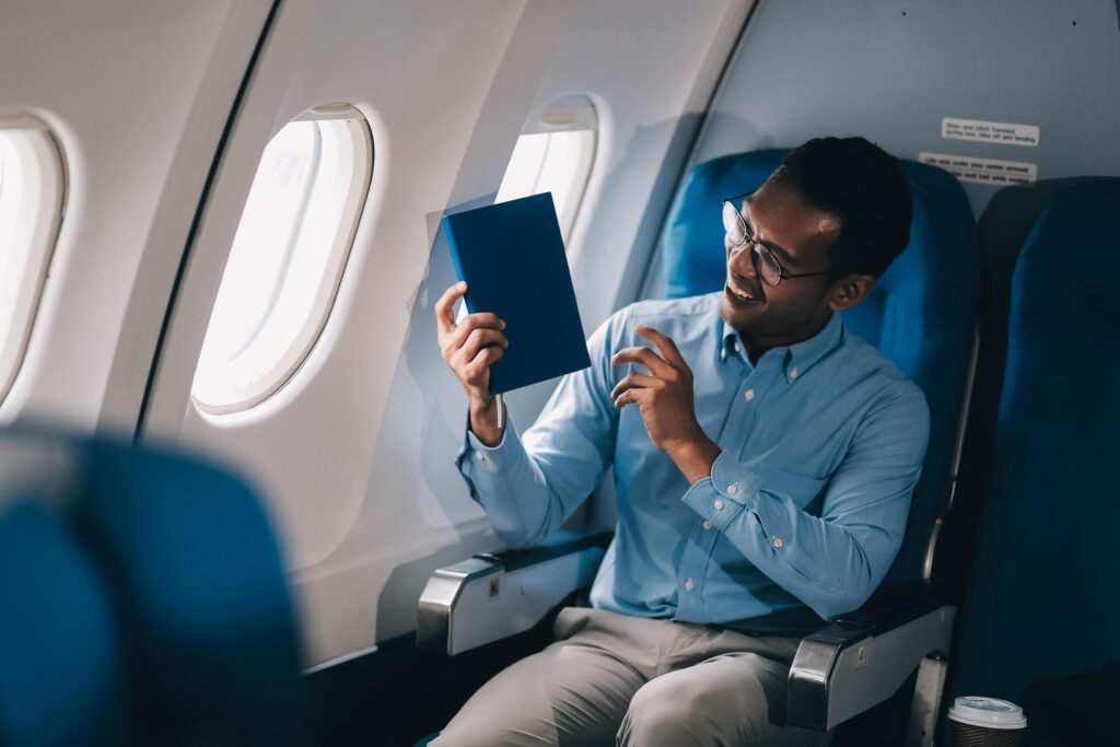 Airplane, travel and portrait of businessman working on laptop computer and smartphone while sitting in airplane. Stock Free