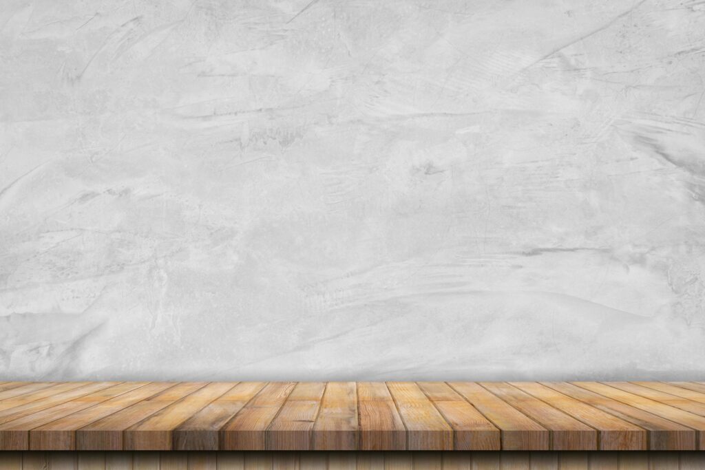 old cement wall interior vintage and wooden table background. Stock Free