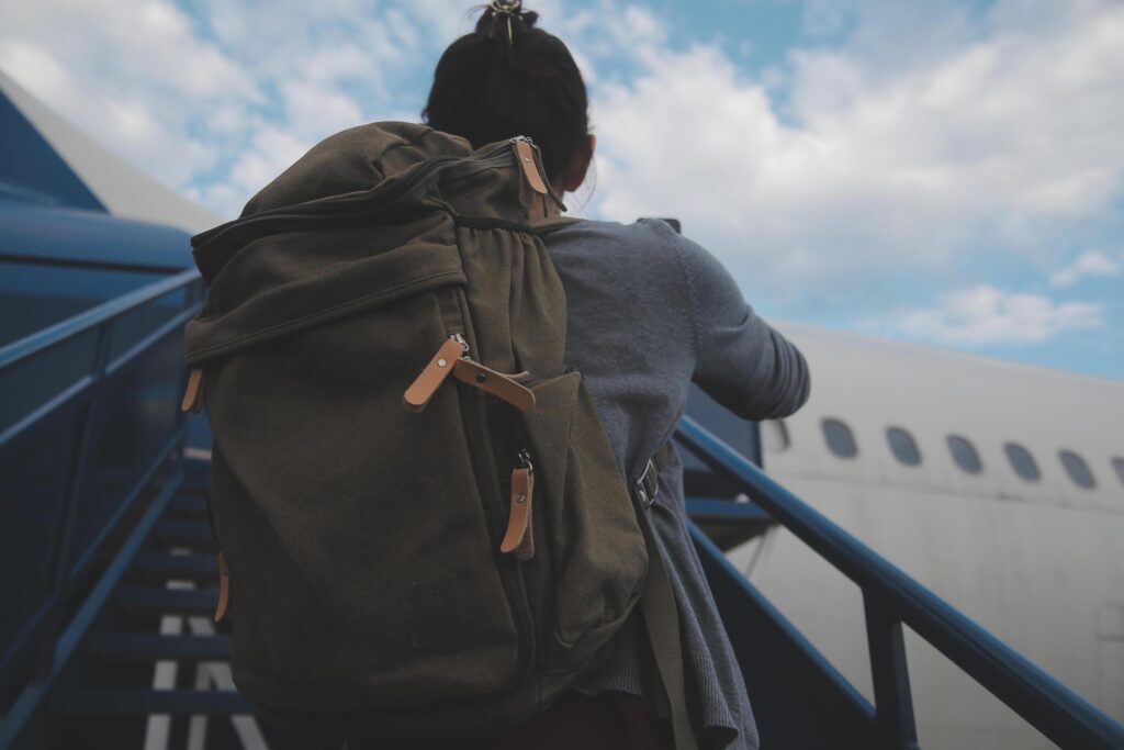 Happy attractive asian woman traveler with backpack at the modern airport terminal, copy space, Tourist journey trip concept Stock Free