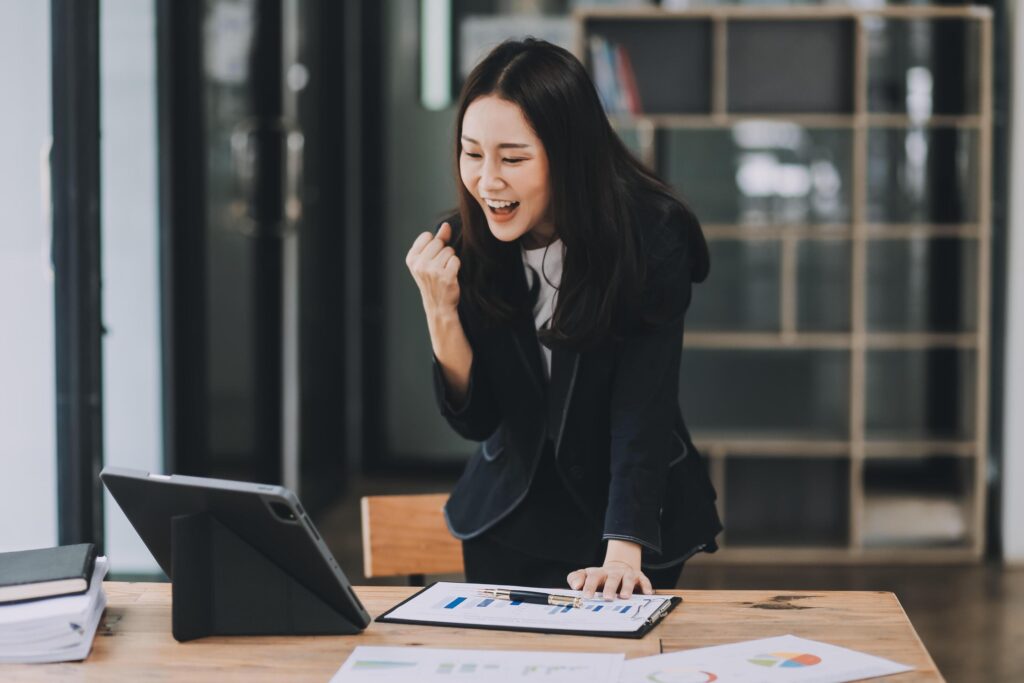 Asian business woman are delighted and happy with the work they do on their tablet, laptop and taking notes at the modern office. Stock Free