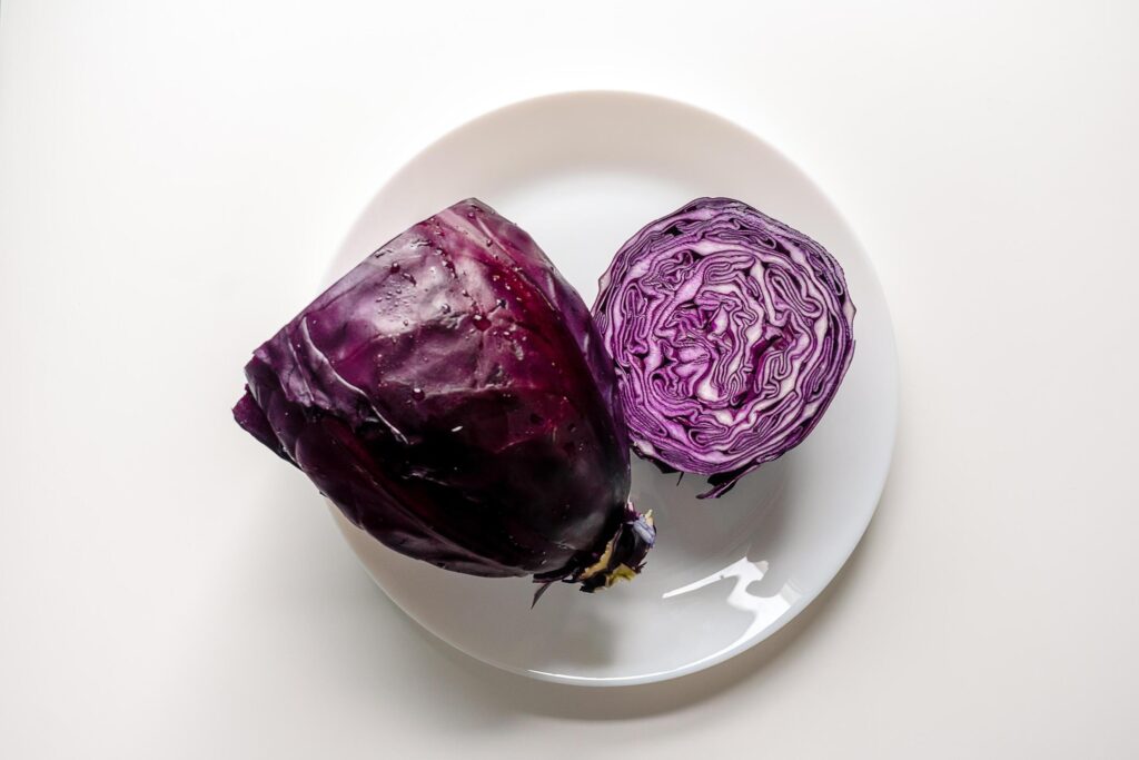 Red cabbage on a large white plate. Cut red cabbage on a white background. Stock Free