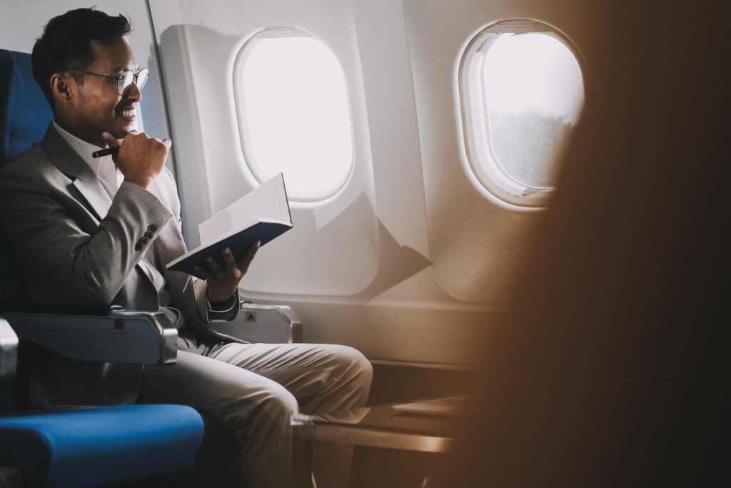 Airplane, travel and portrait of businessman working on laptop computer and smartphone while sitting in airplane. Stock Free