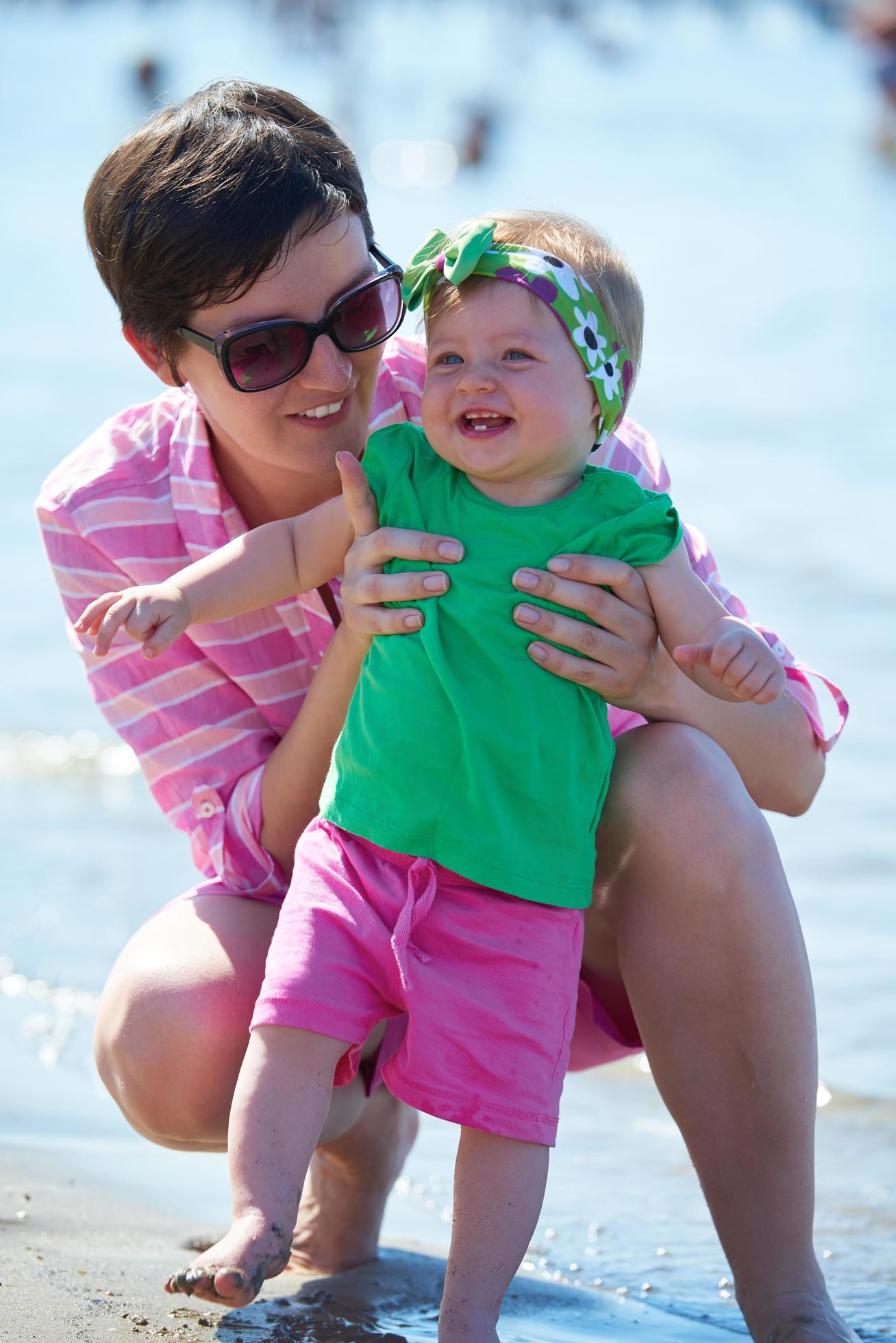 mom and baby on beach have fun Stock Free