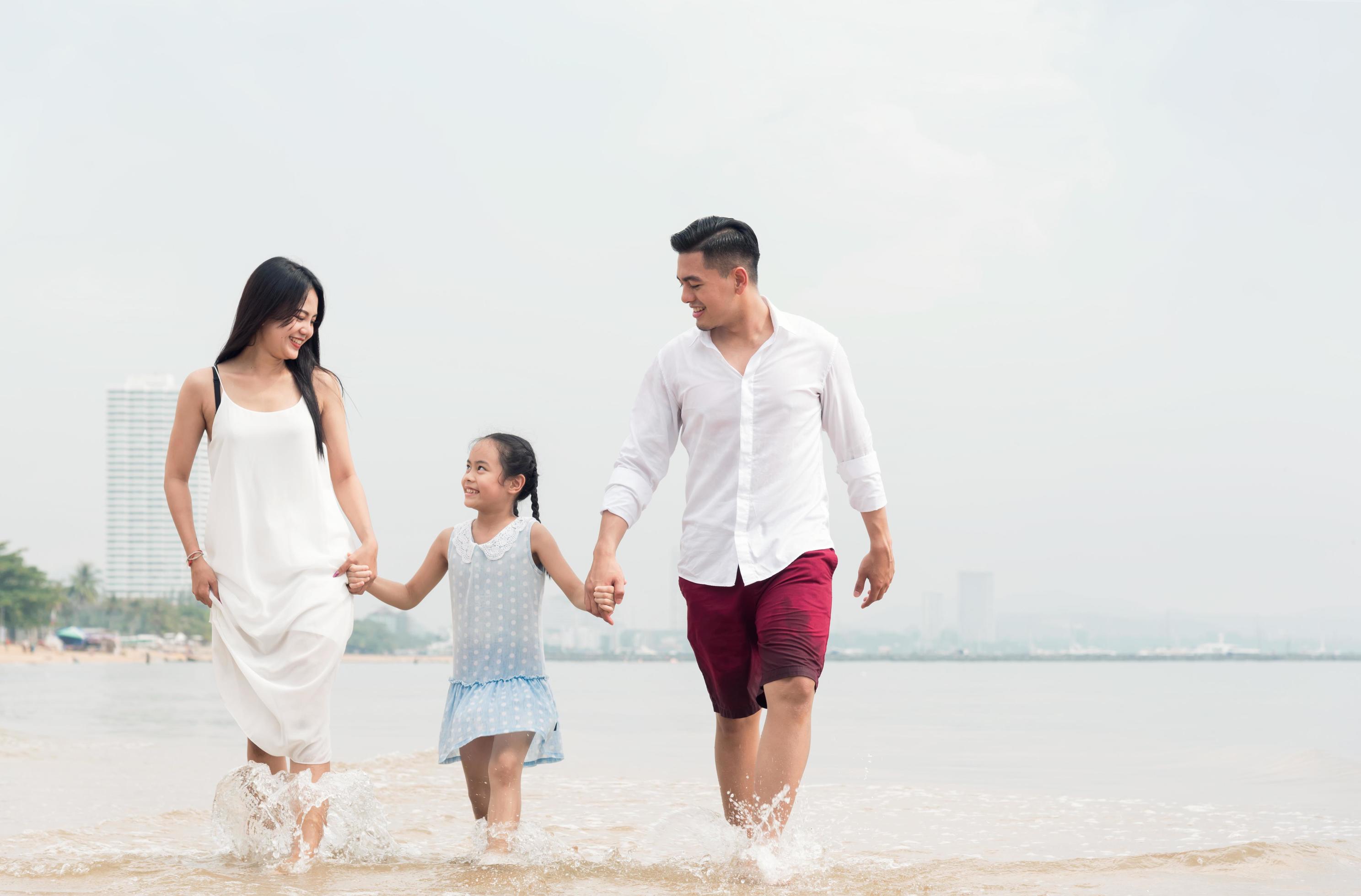 Happy family on beach run and jump at sunset Stock Free