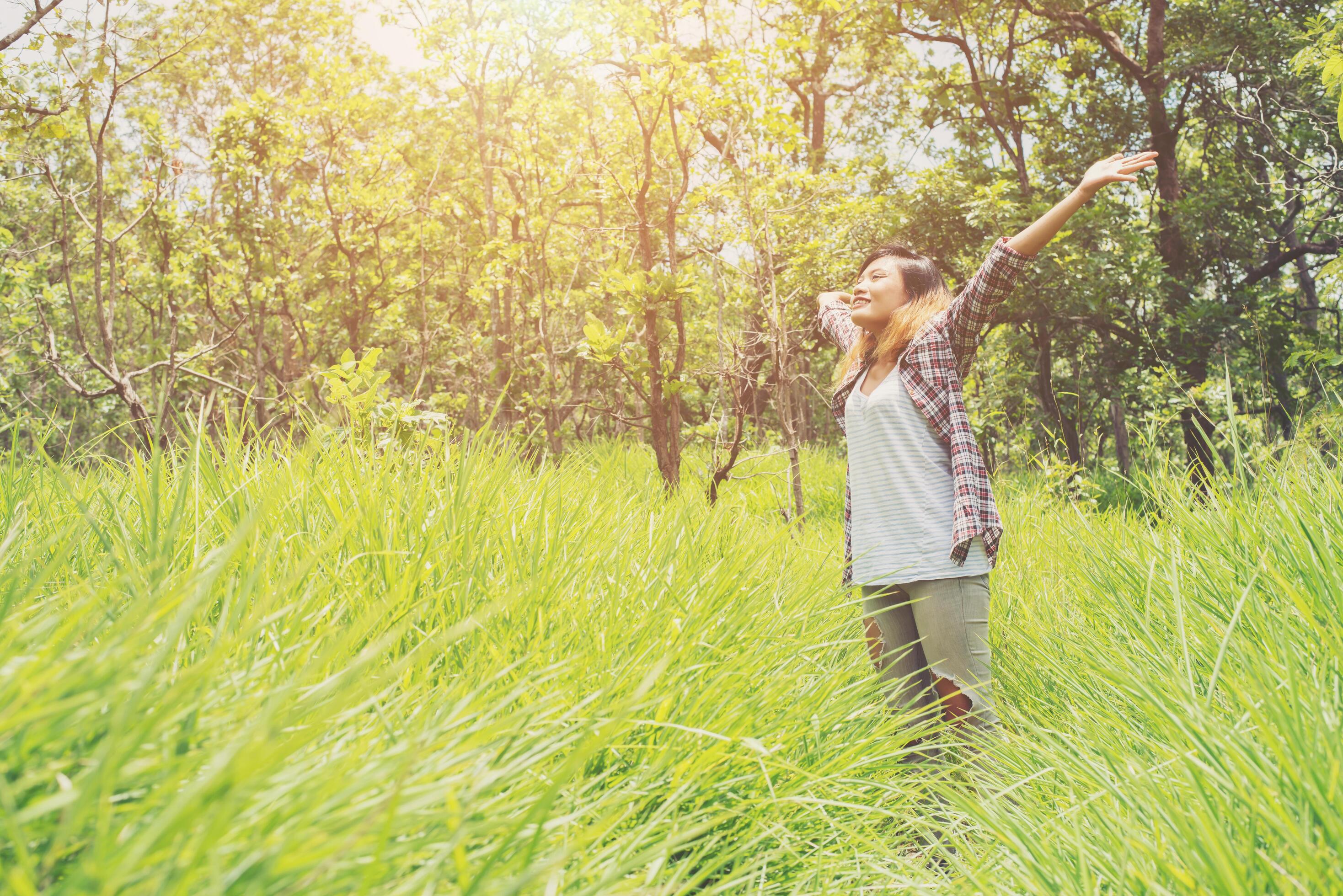 Freedom hipster woman raising hands in the air,enjoying with nature. Stock Free