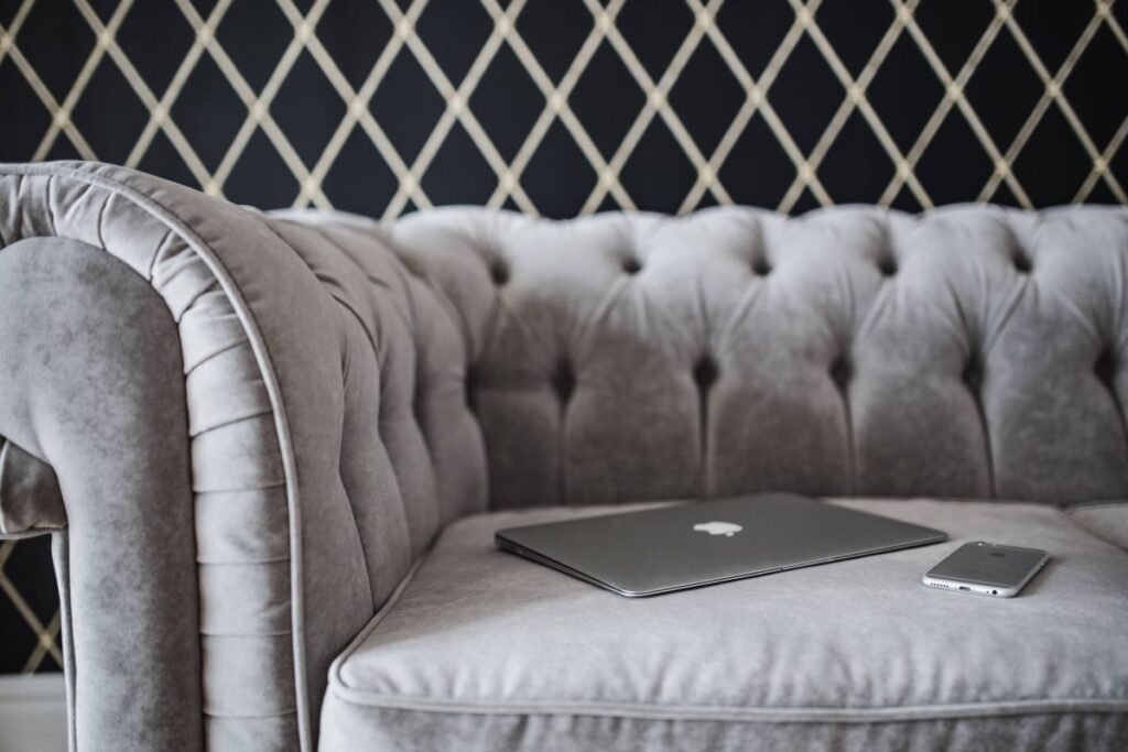 Elegant grey sofa with a laptop, an iPhone and a magazine Stock Free