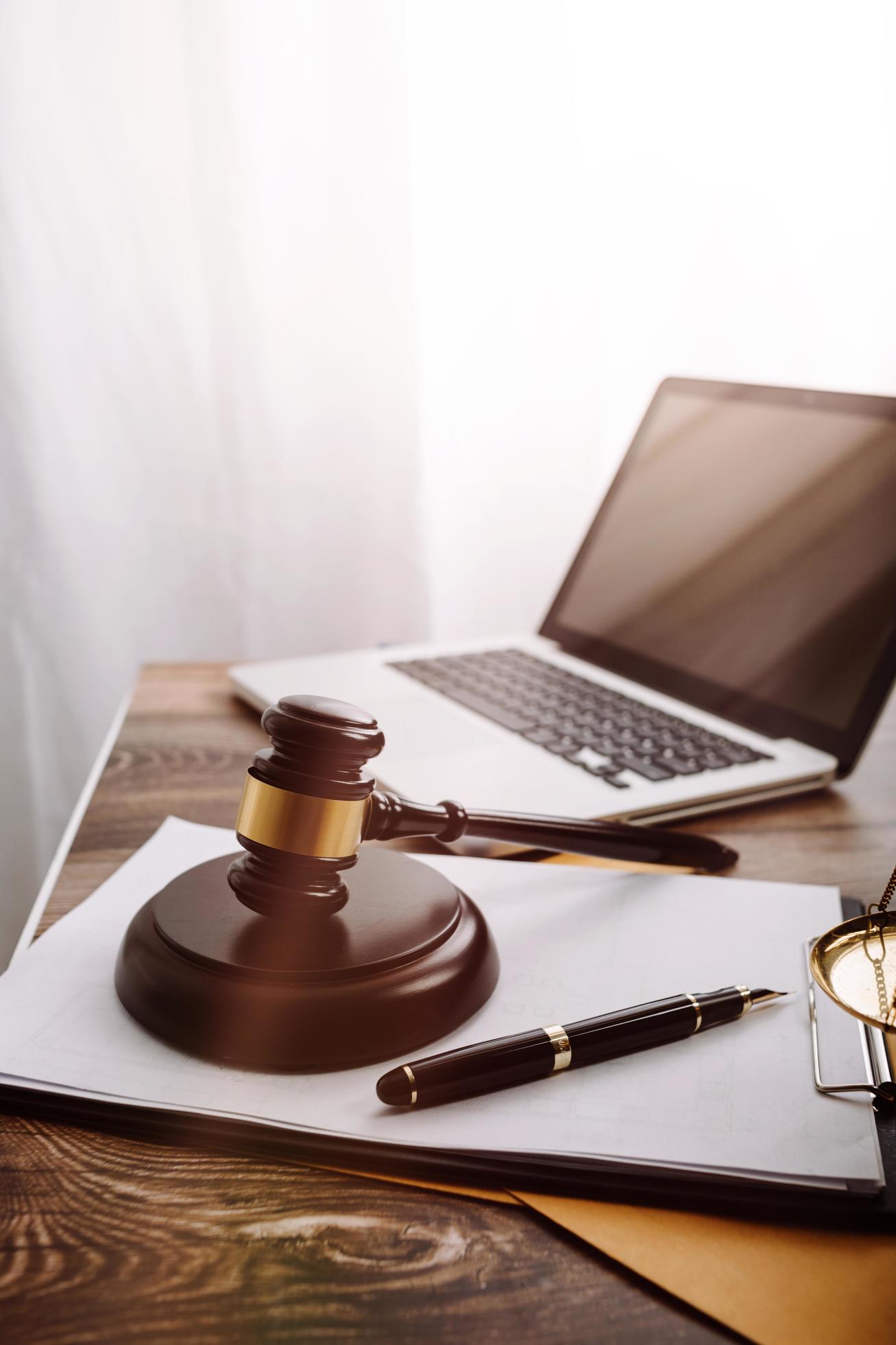 Justice and law concept.Male judge in a courtroom with the gavel, working with, computer and docking keyboard, eyeglasses, on table in morning light Stock Free