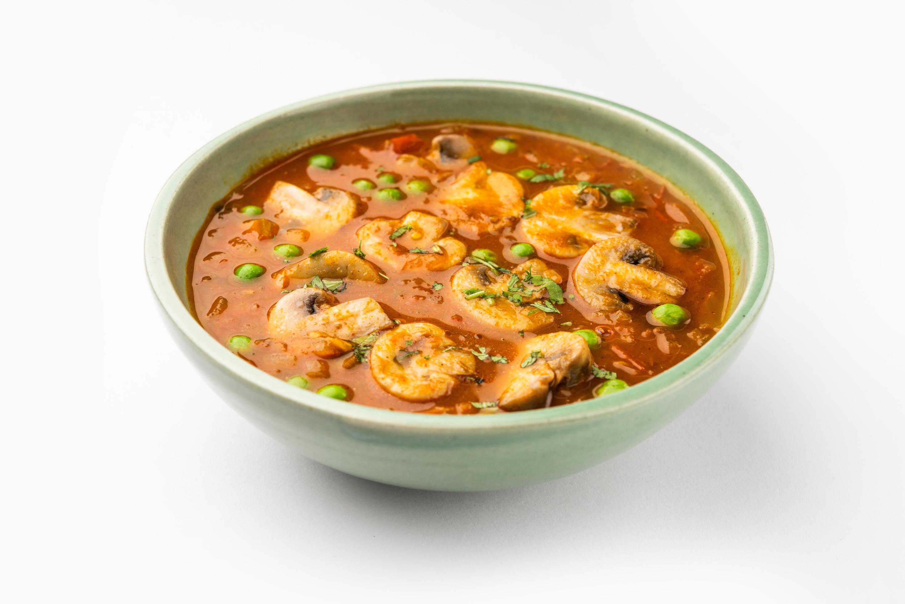 Mushroom and Pea Curry with Roasted Garlic, Indian food served in a bowl Stock Free