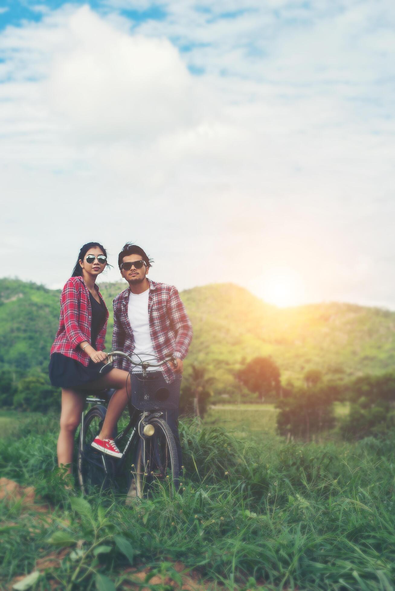 Young hipster couple holding hands walking on the meadow relaxing and natural atmosphere is very natural. Stock Free