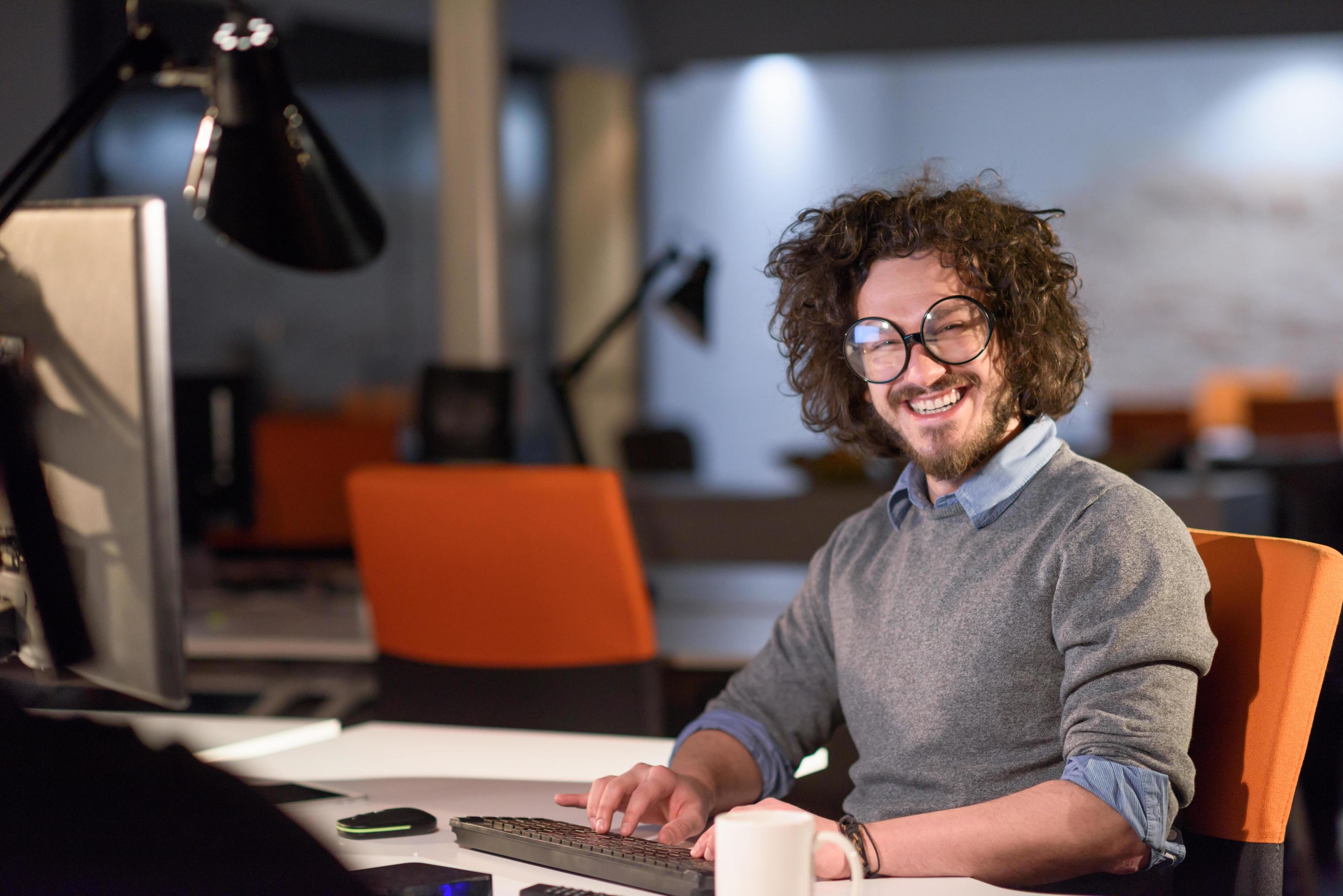 man working on computer in dark startup office Stock Free