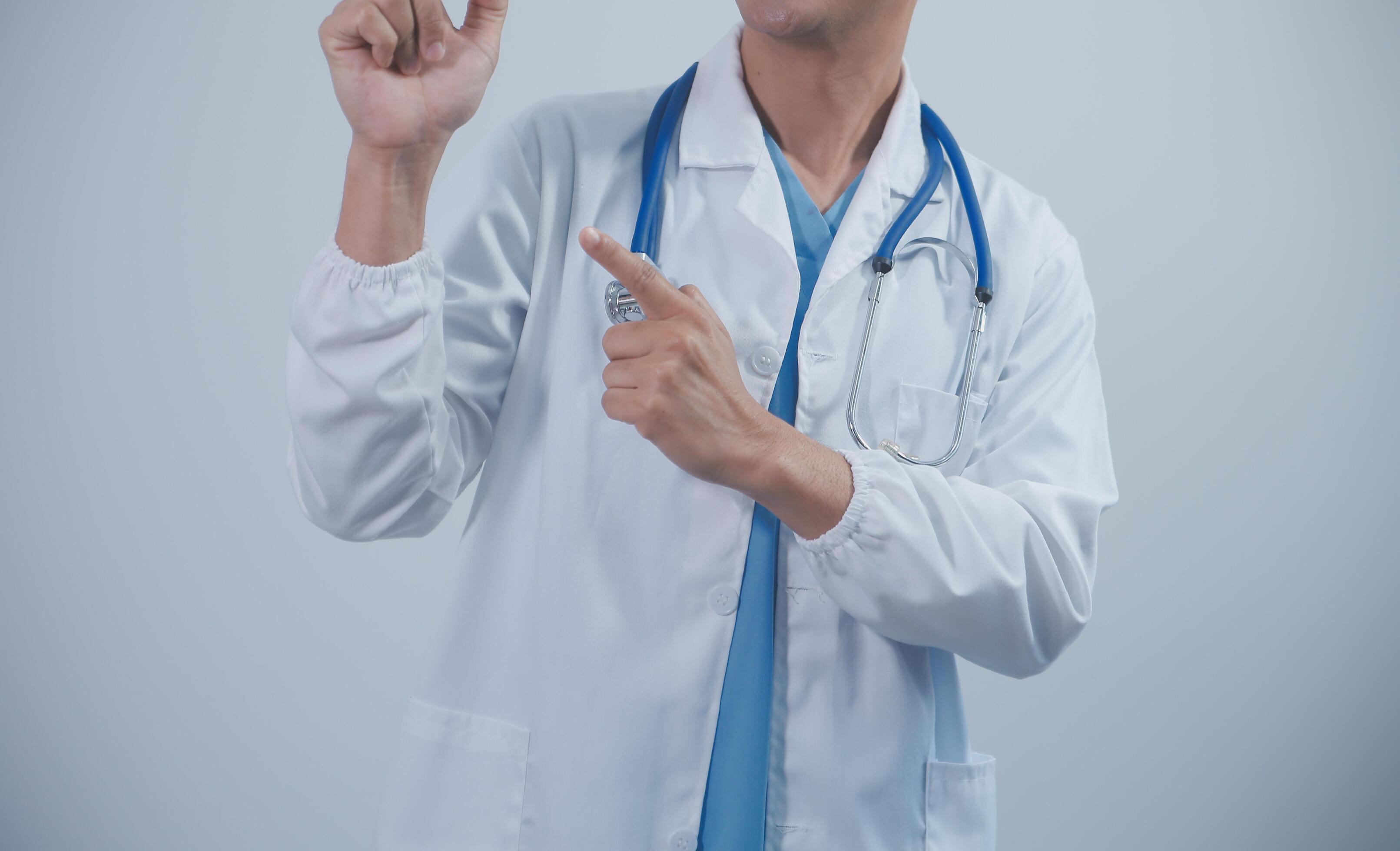 Mature male doctor with tablet pc is giving presentation. Blurred background indoors. Stock Free