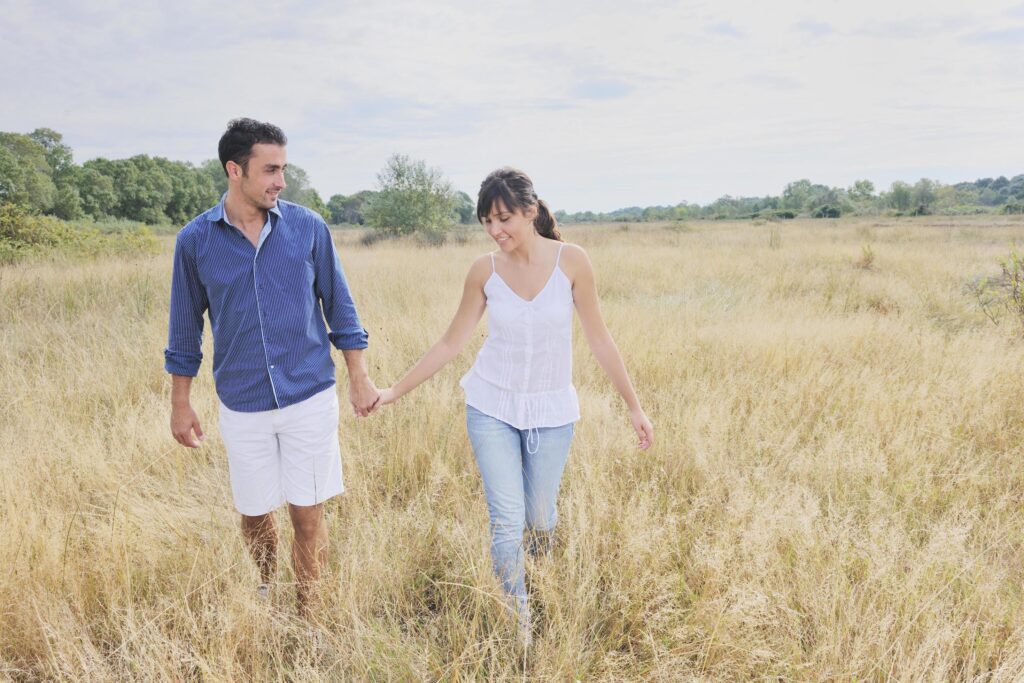 happy couple enjoying countryside picnic in long grass Stock Free