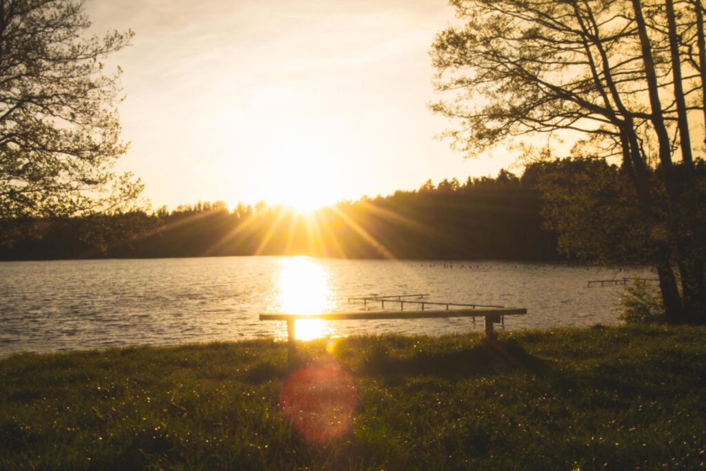 Panoramic view of calm Pageluvis lake during sunset with couple standing in front. Pristine nature and lakes in Lithuania countryside Stock Free