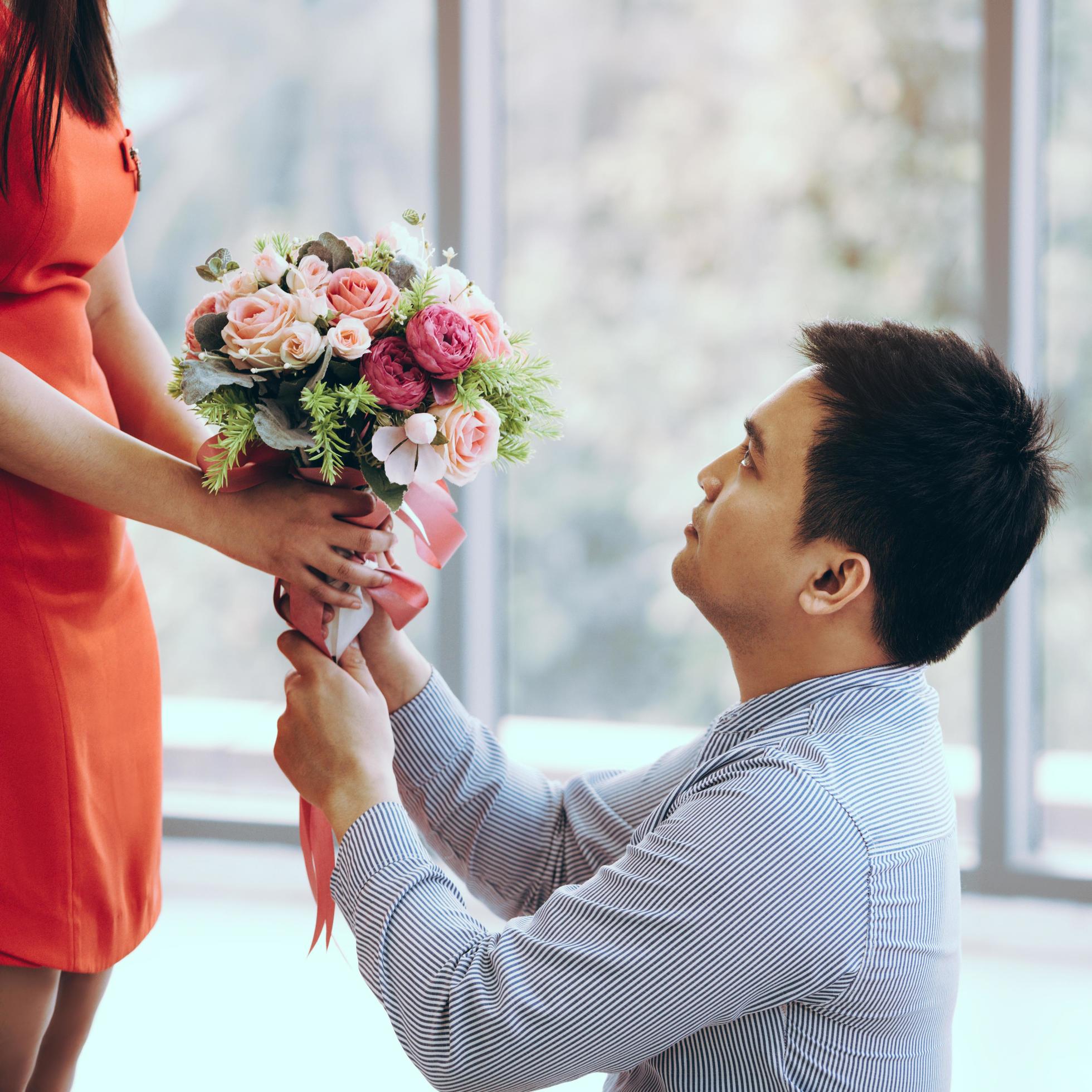 Adult asian man give a flower bouquet to girlfriend in romantic date. Stock Free