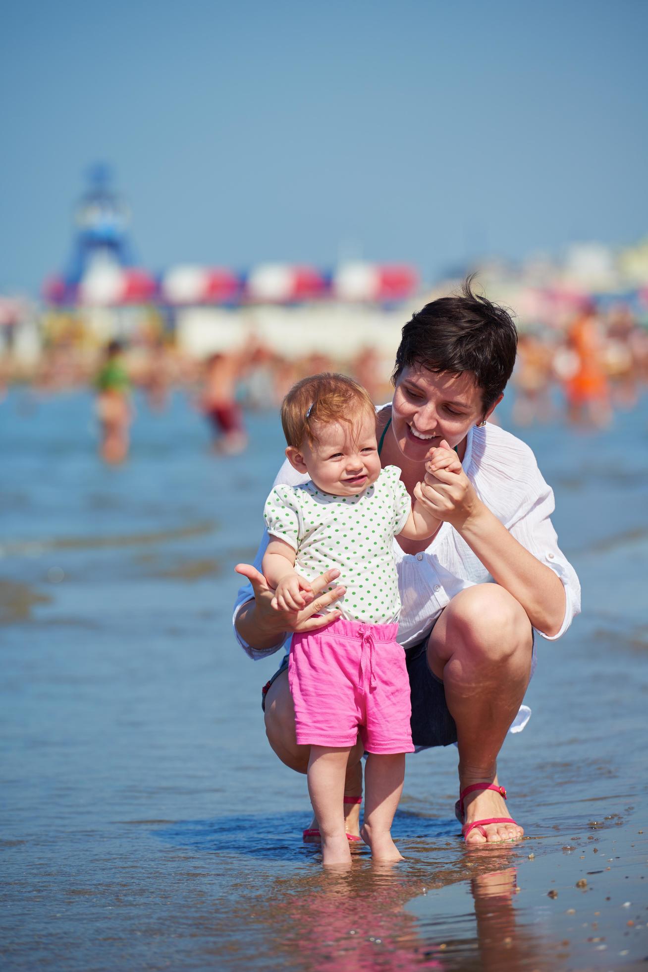 mom and baby on beach have fun Stock Free