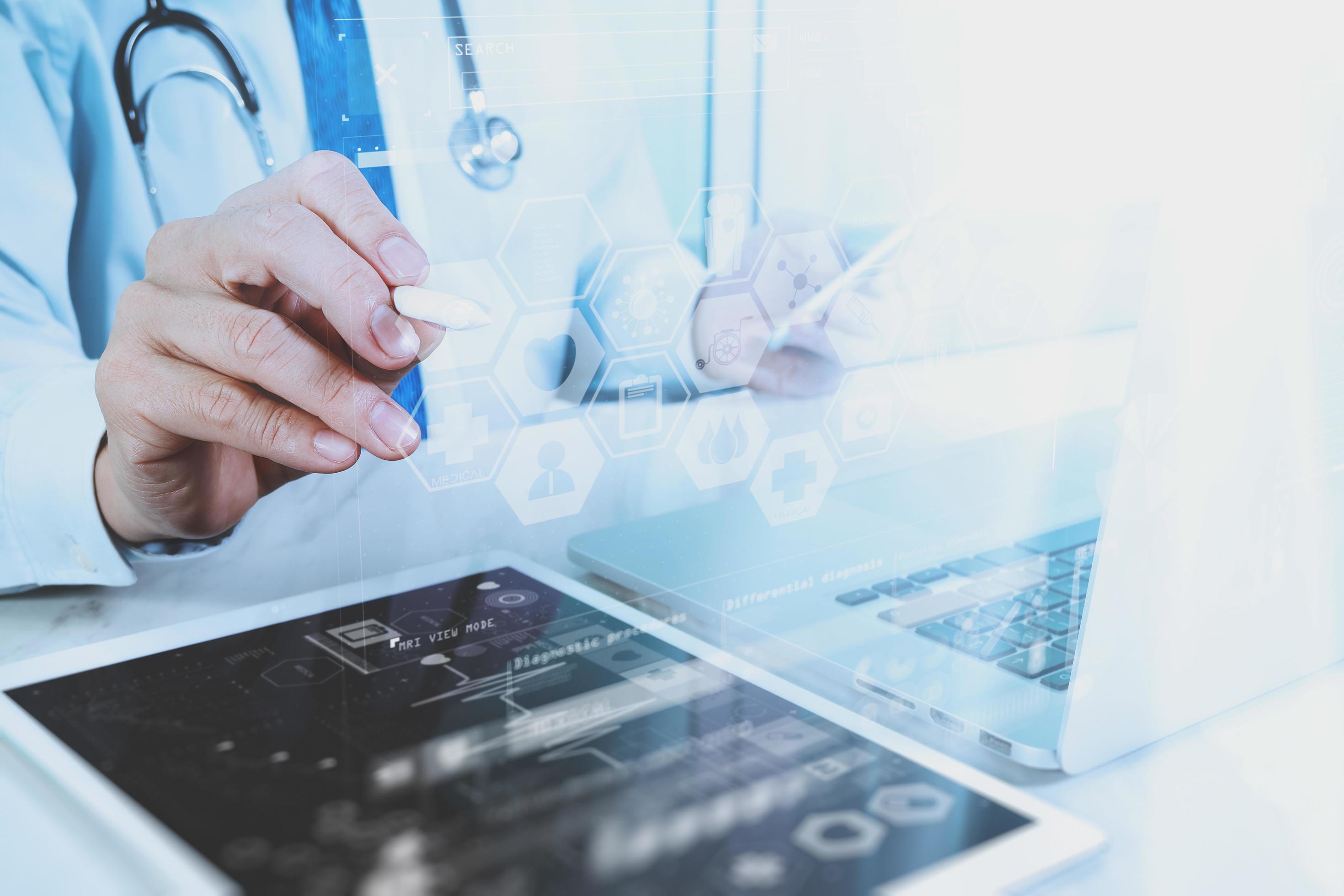 Medical technology concept. Doctor hand working with modern digital tablet and laptop computer with medical chart interface, Sun flare effect photo Stock Free