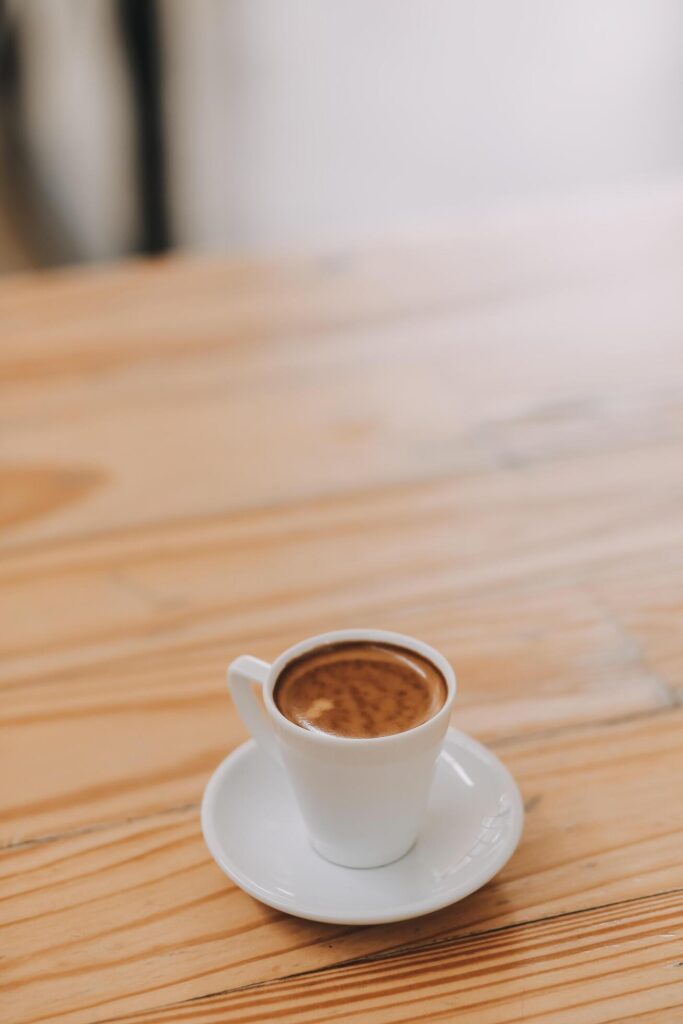 Closeup of coffee cup on table in empty corporate conference room before business meeting in office Stock Free