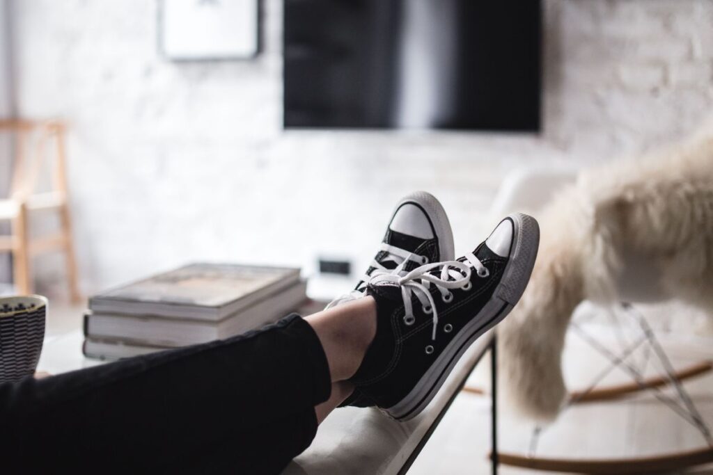 Young woman sitting on the sofa and working on her laptop Stock Free